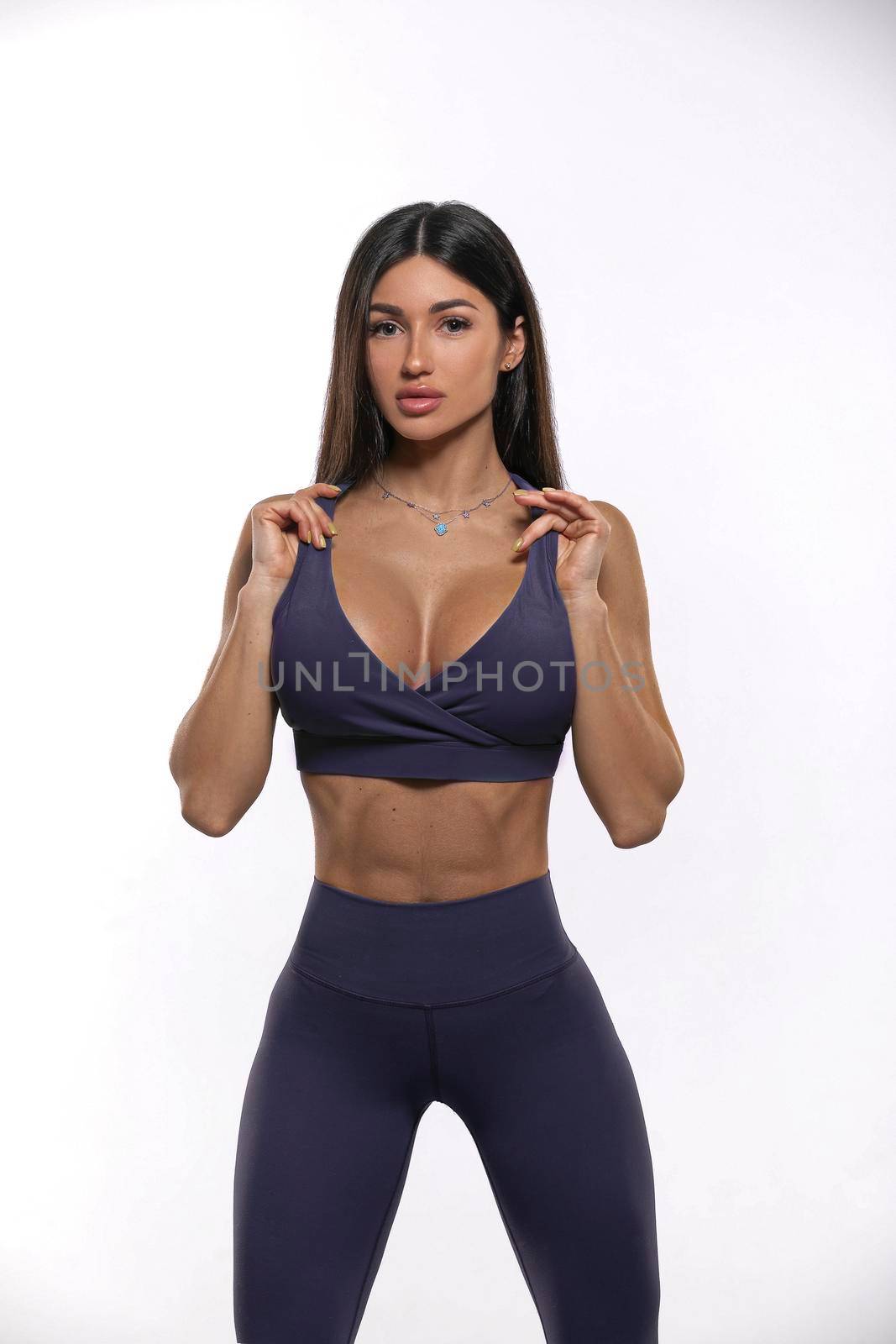 girl in purple leggings and top on a white background by but_photo
