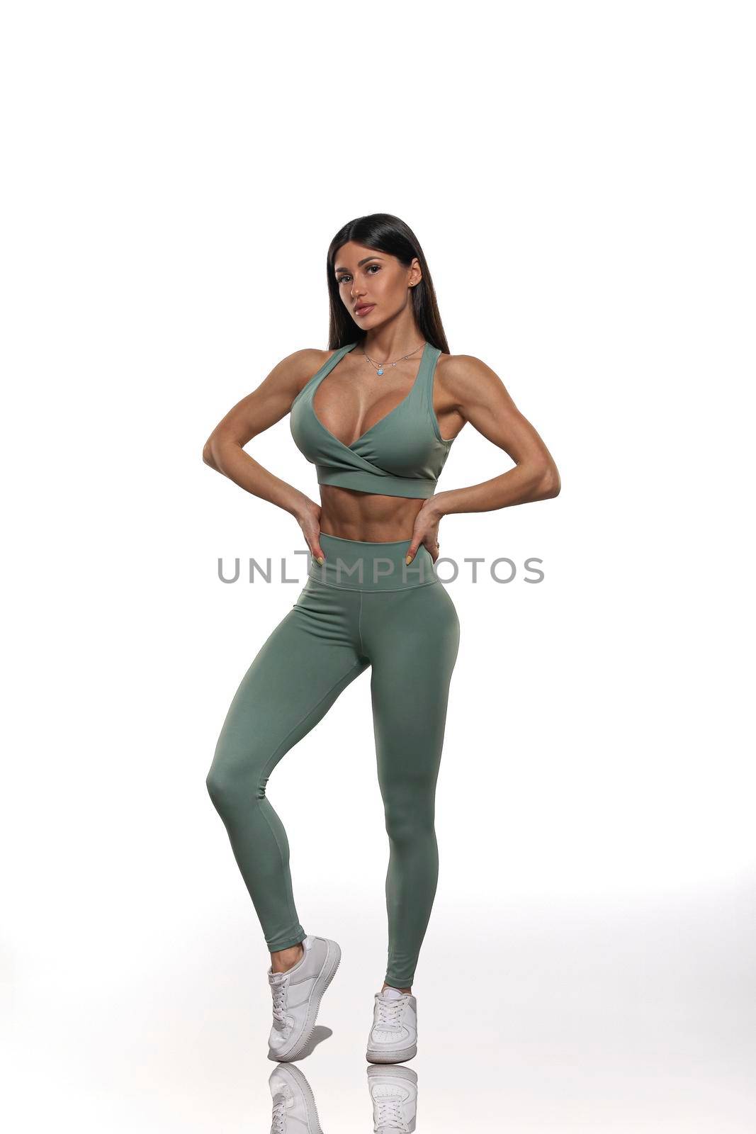 brunette girl in olive leggings and top on a white background
