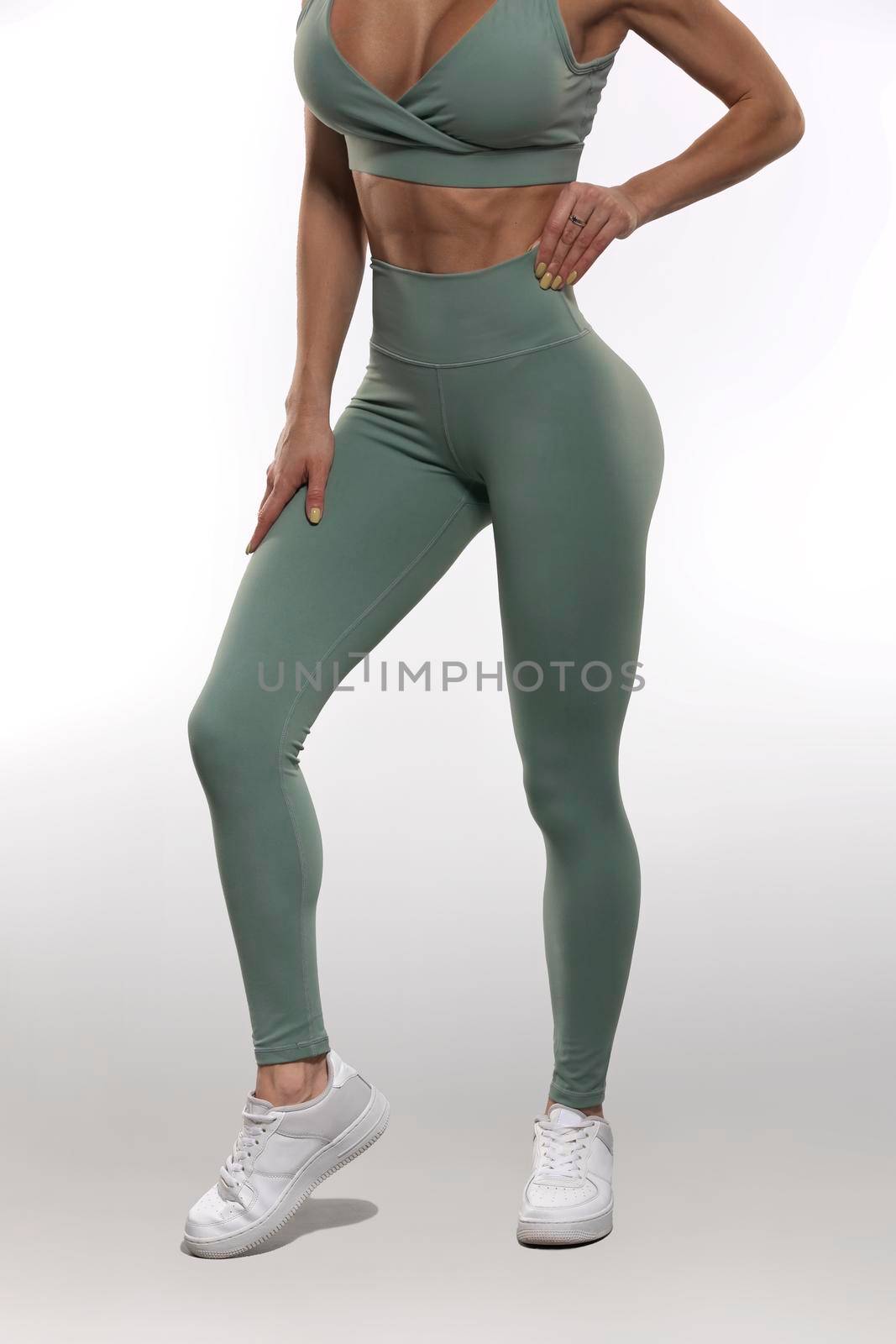legs brunette girl in olive leggings and top on a white background