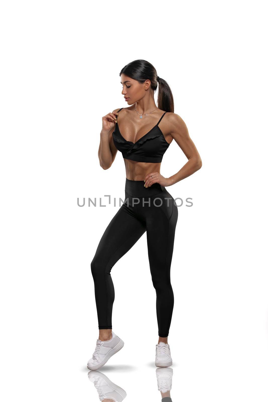 brunette girl in black leggings and a top on a white background