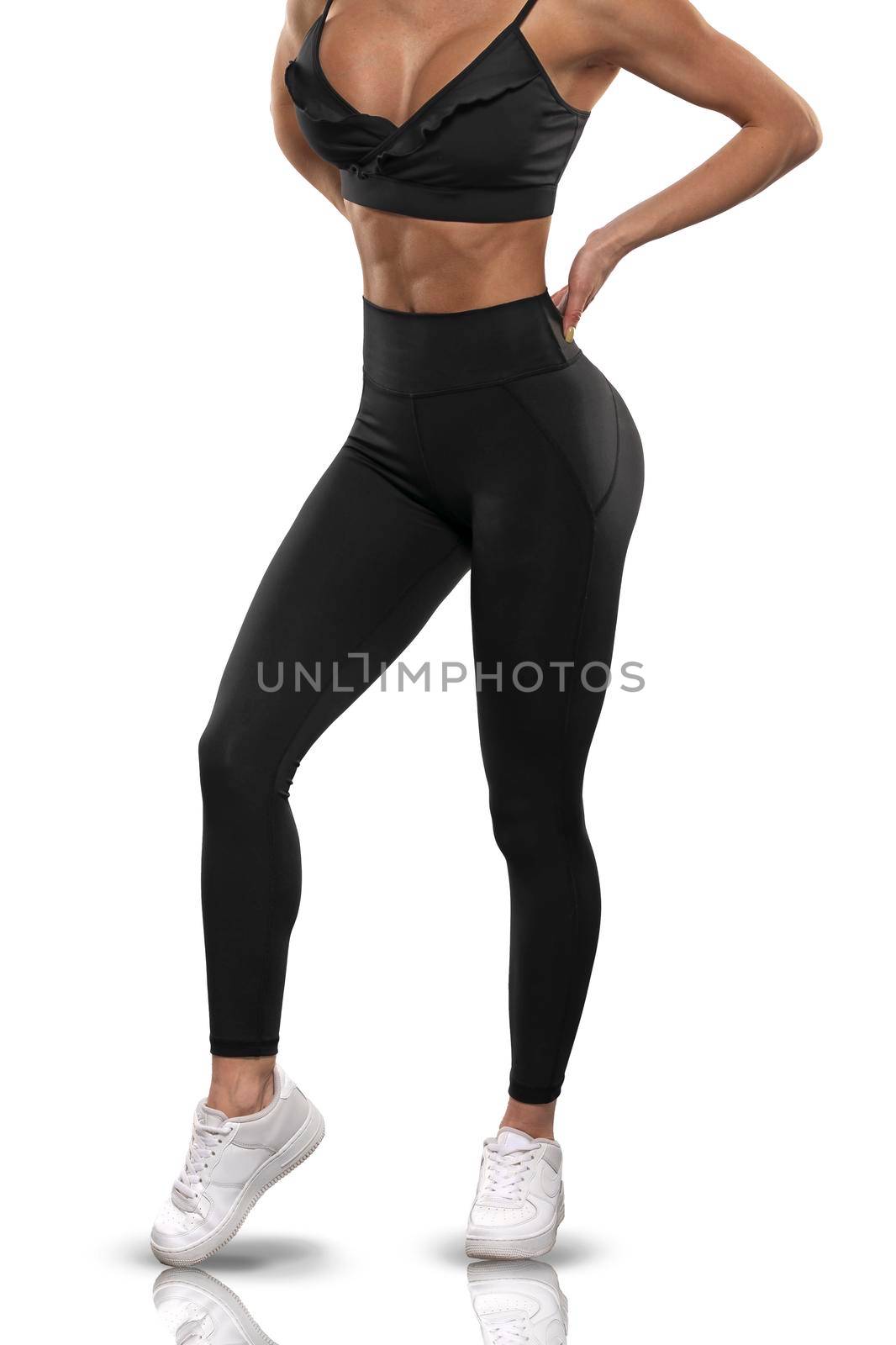 Legs girl in black leggings and a top on a white background by but_photo