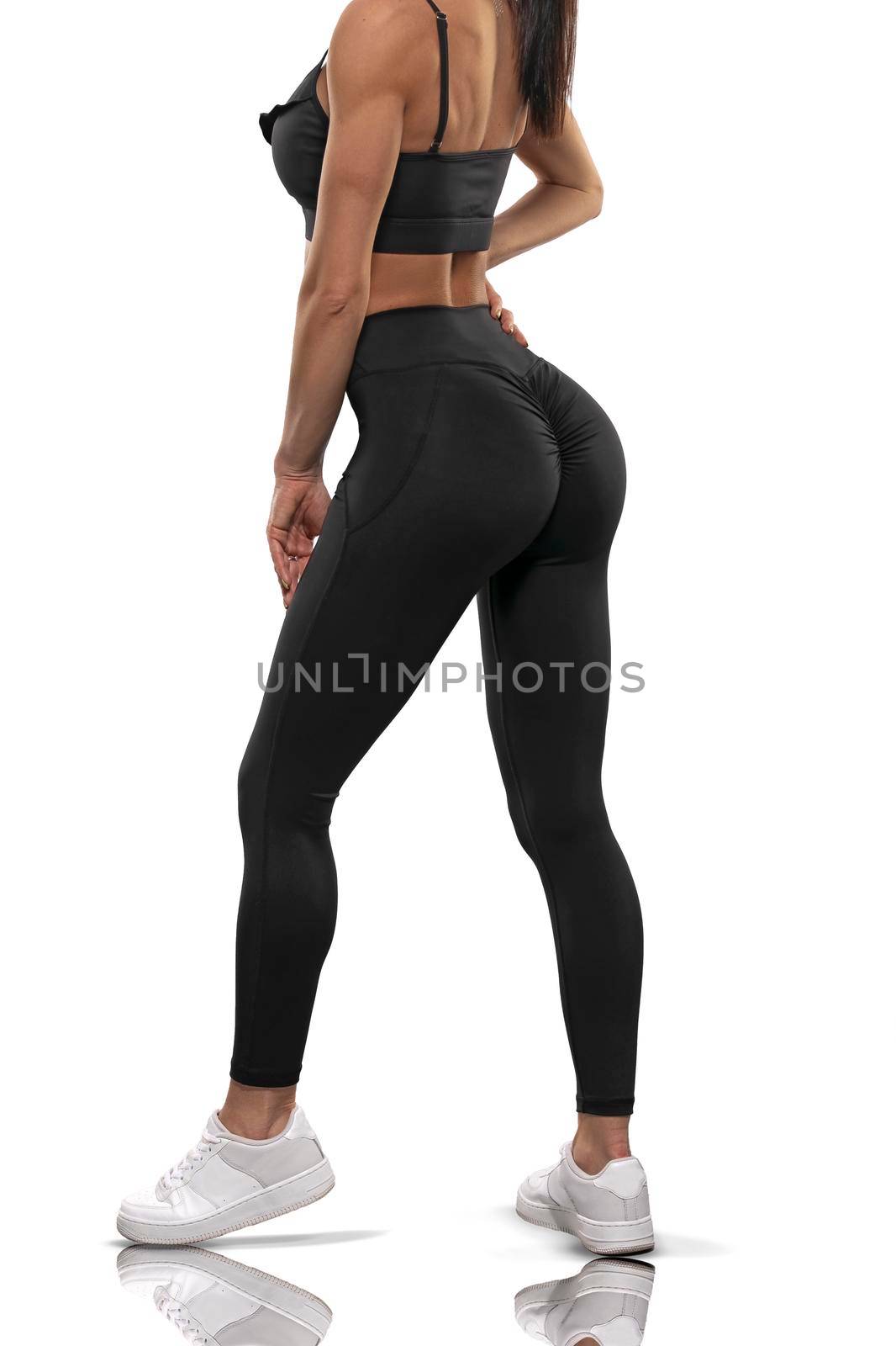 Legs girl in black leggings and a top stay back on a white background by but_photo