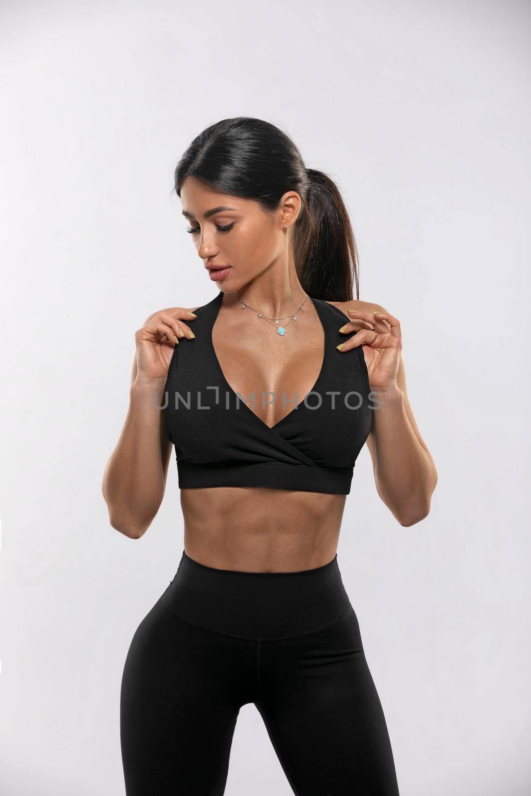 girl in black leggings and a top on a white background by but_photo