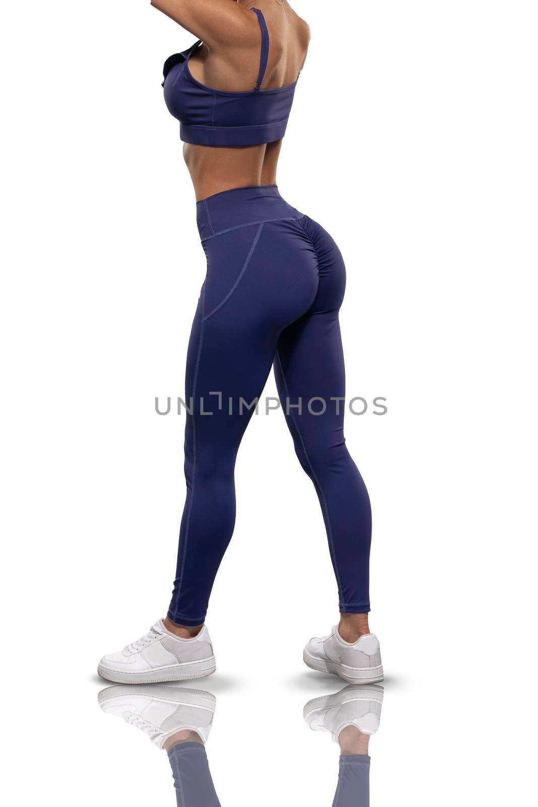 legs brunette girl in blue leggings and top stay back on a white background