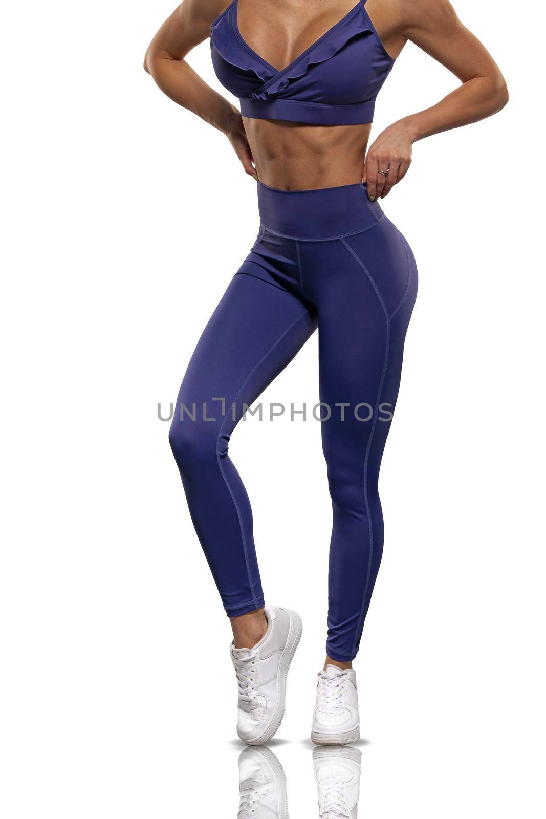 legs brunette girl in blue leggings and top on a white background