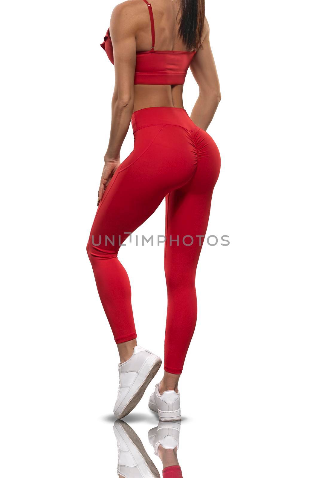 legs brunette girl in red leggings and a top stay back on a white background