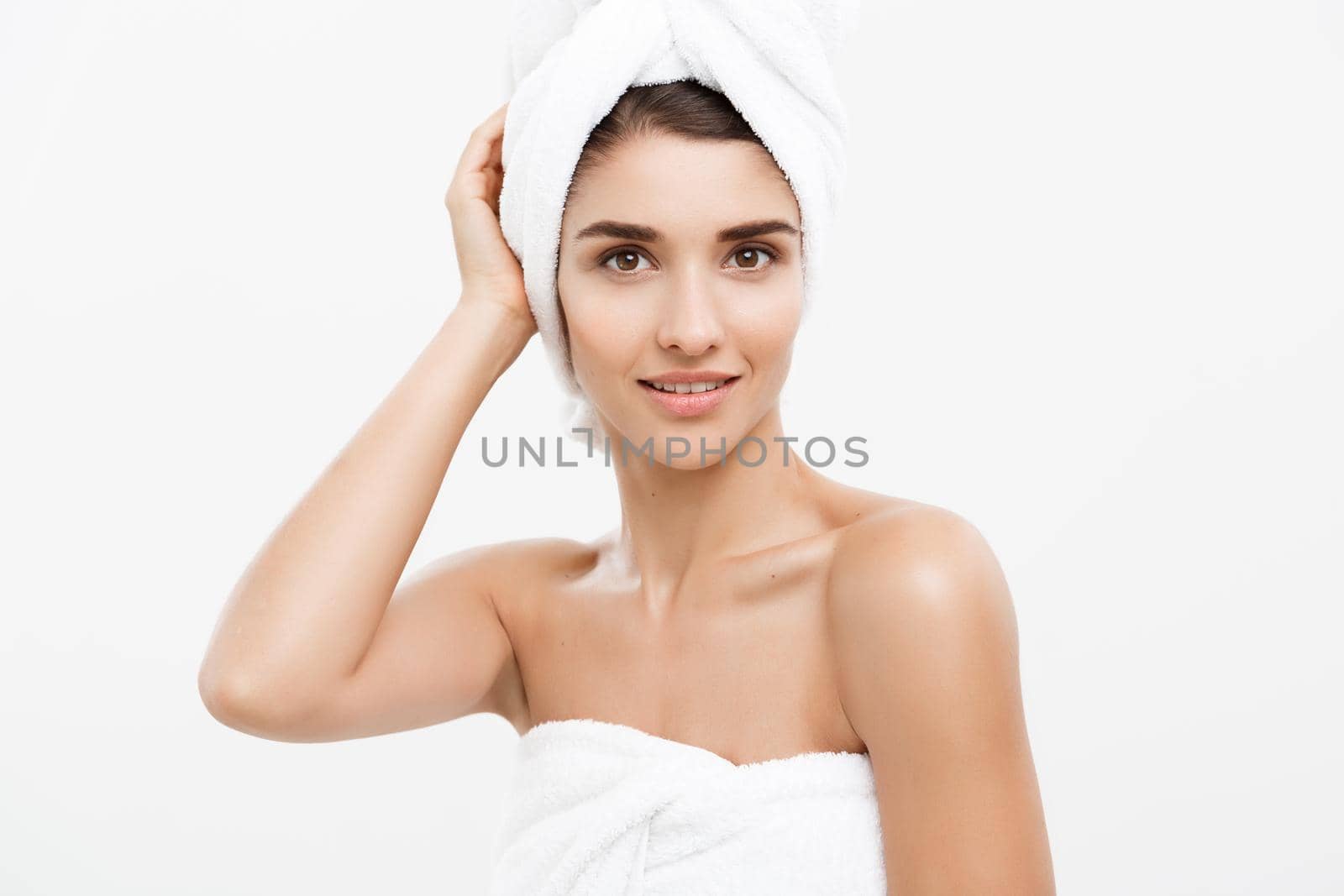 Beauty and Skin care concept - Beautiful caucasian Young Woman with bath towel on head covering her breasts, on white. by Benzoix