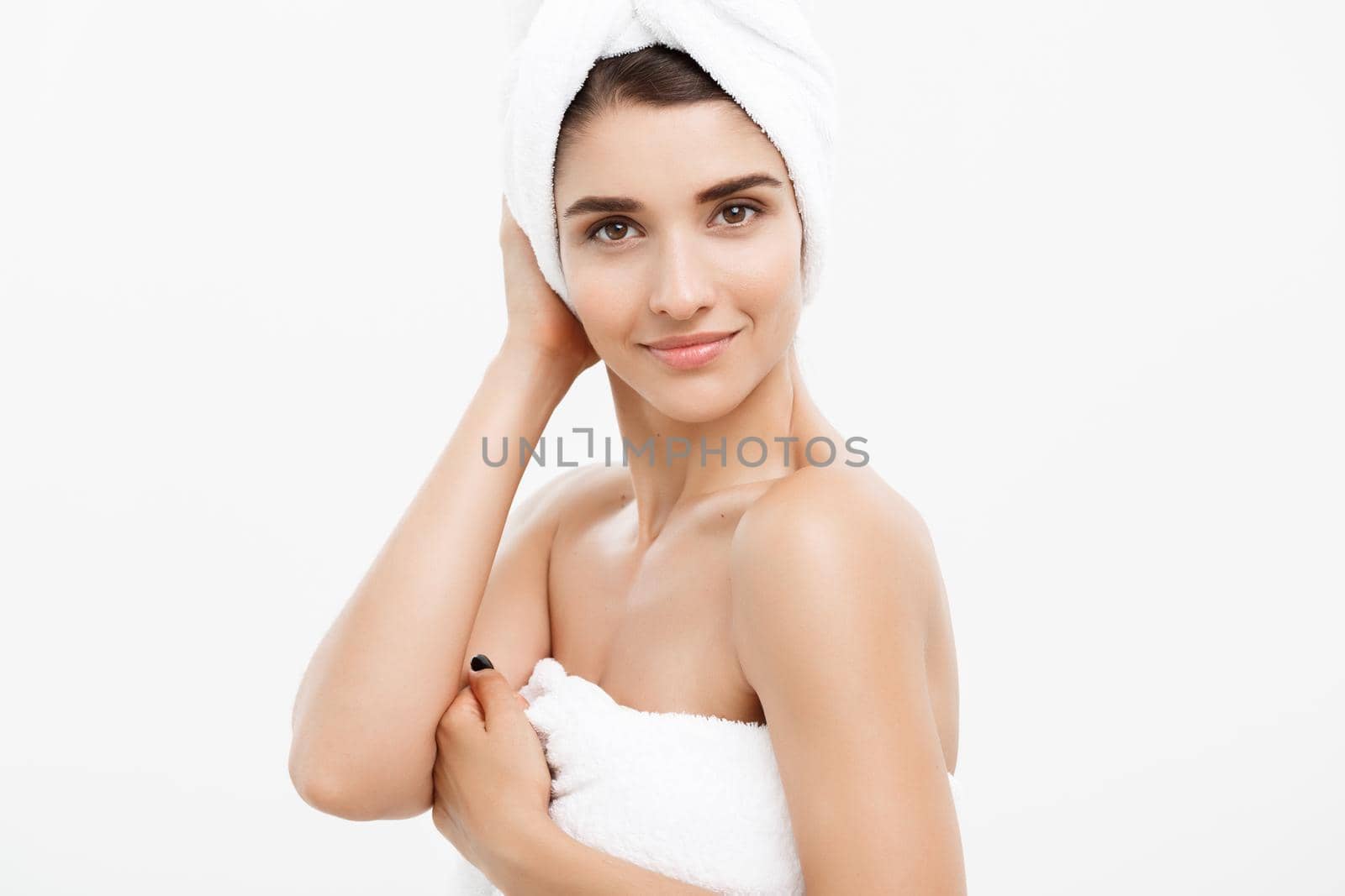 Beauty and Skin care concept - Beautiful caucasian Young Woman with bath towel on head covering her breasts, on white
