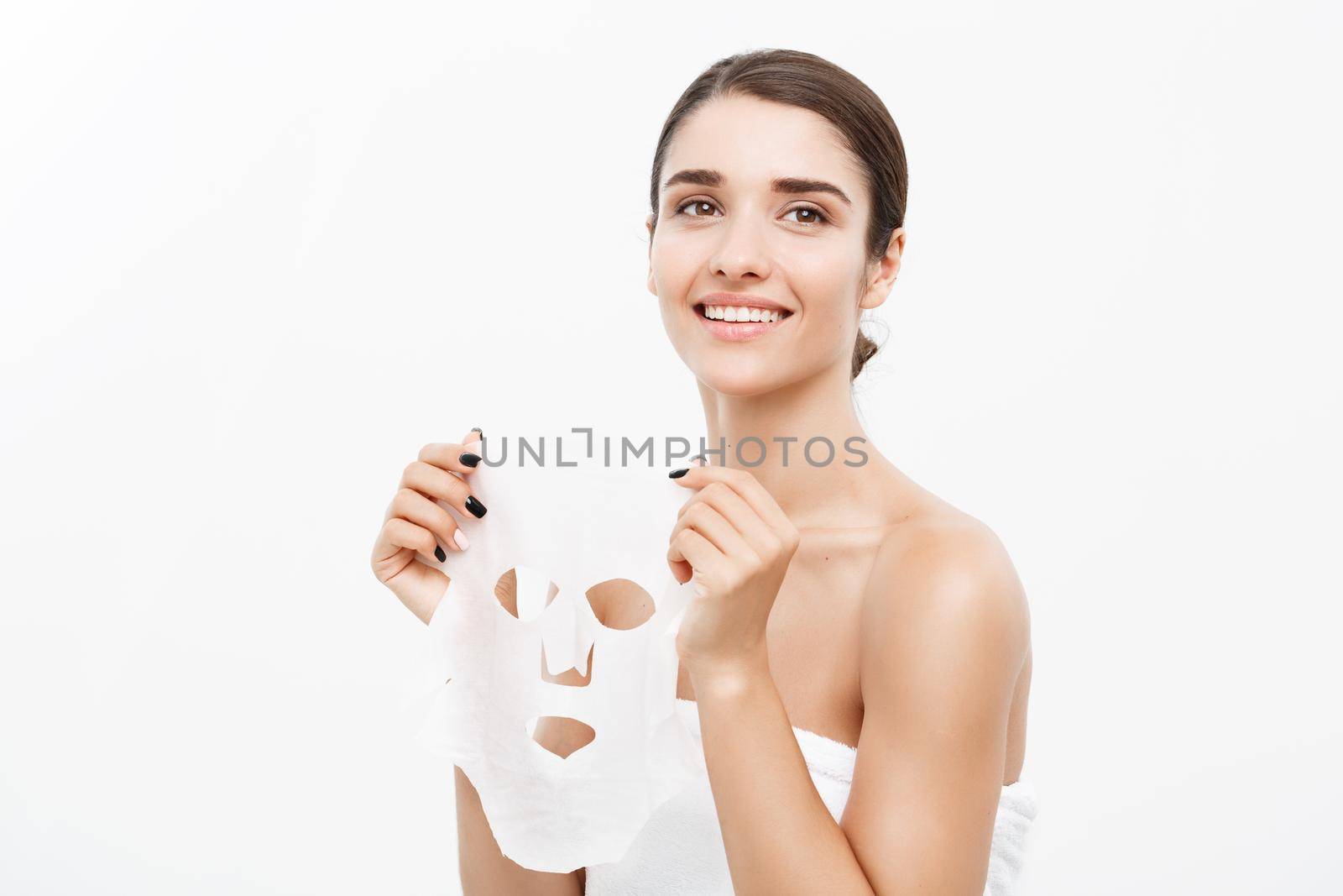 Beauty Skin Care Concept - Beautiful Caucasian Woman applying paper sheet mask on her face white background. by Benzoix