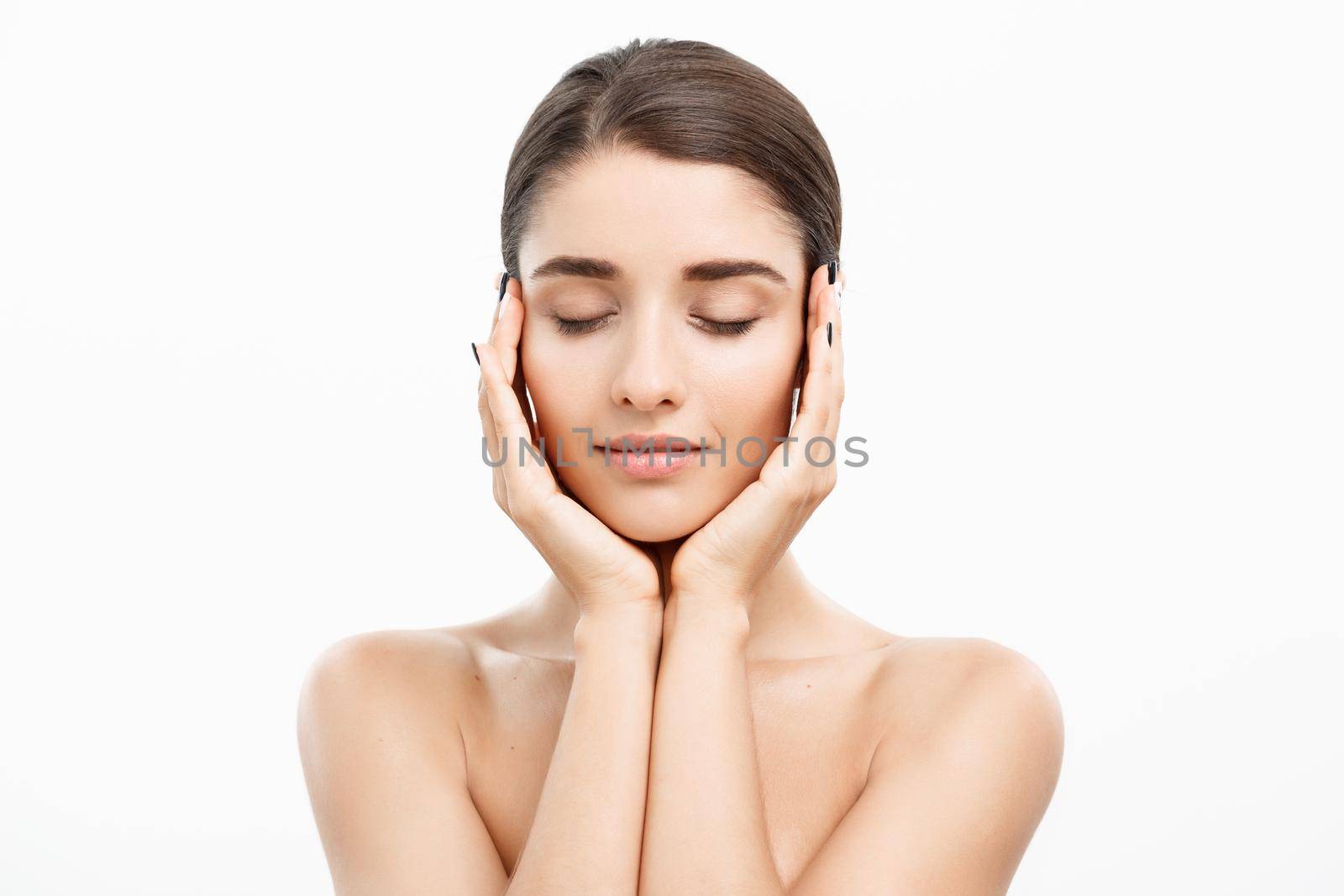 Beauty Skin Care Concept - Beautiful Caucasian Woman Face Portrait. Beautiful beauty young female model girl touching her face skin cheeks hands fingers. Fashion Beauty Model isolated on white.