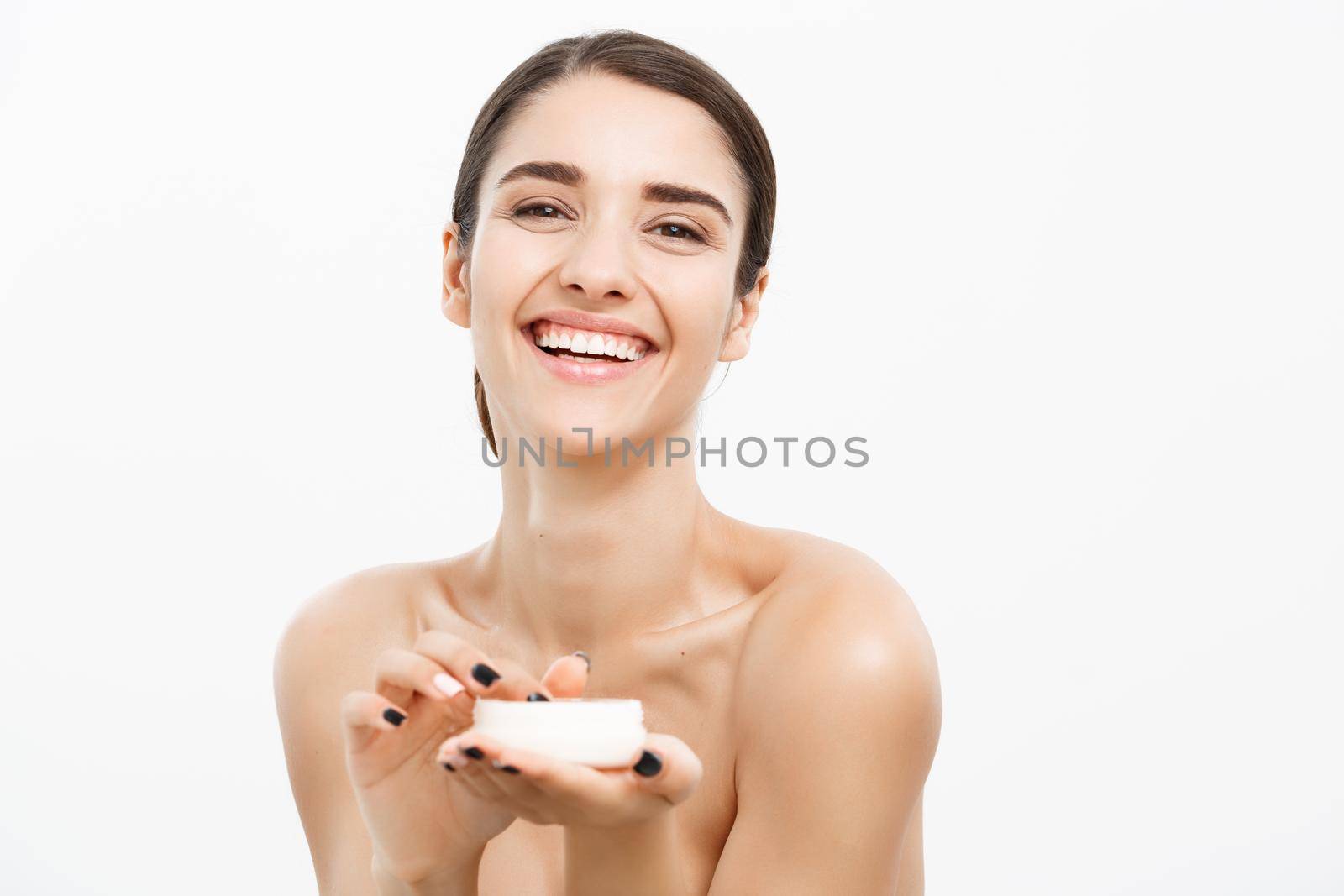 Beauty Youth Skin Care Concept - Beautiful Caucasian Woman Face Portrait smiling and holding cream jar for body and skin.Isolated over white background. by Benzoix