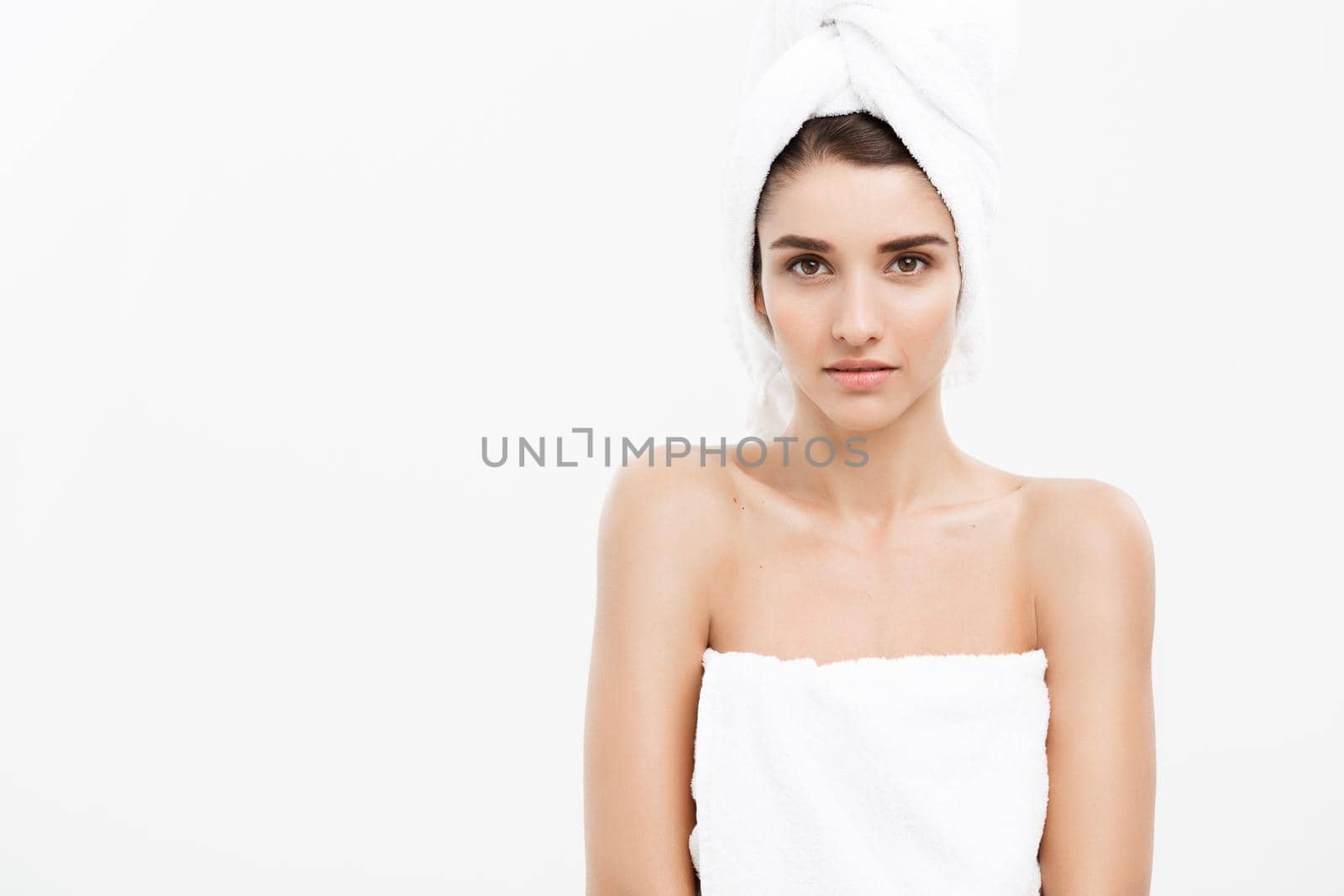 Beauty and Skin care concept - Beautiful caucasian Young Woman with bath towel on head covering her breasts, on white by Benzoix