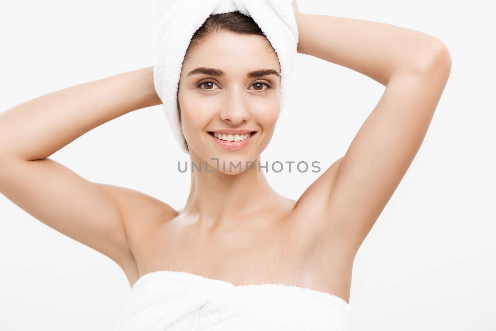 Beauty and Skin care concept - Beautiful caucasian Young Woman with bath towel on head covering her breasts, on white. by Benzoix