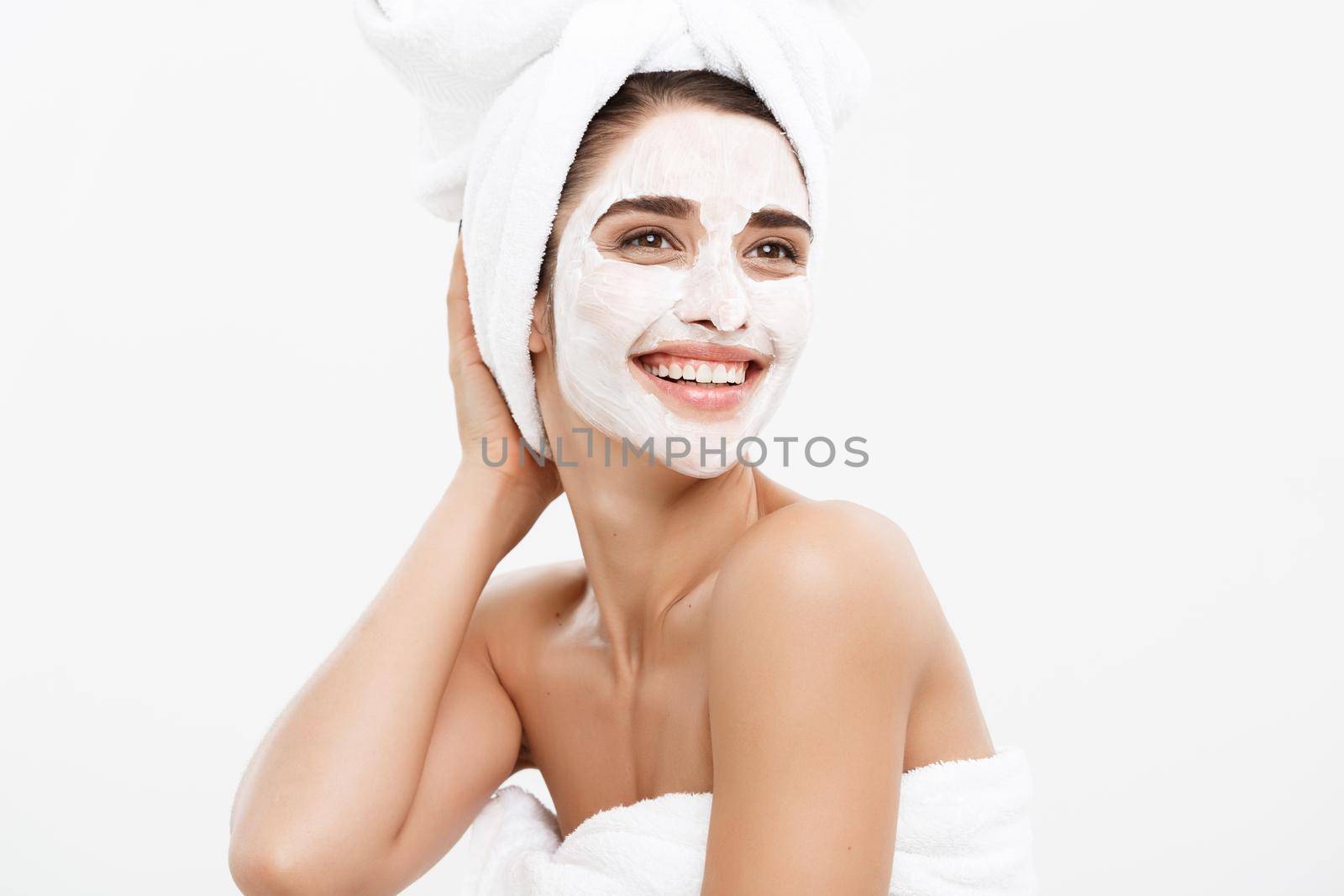 Beauty Skin Care Concept - Beautiful Caucasian Woman Face Portrait applying cream mask on her facial skin white background. by Benzoix