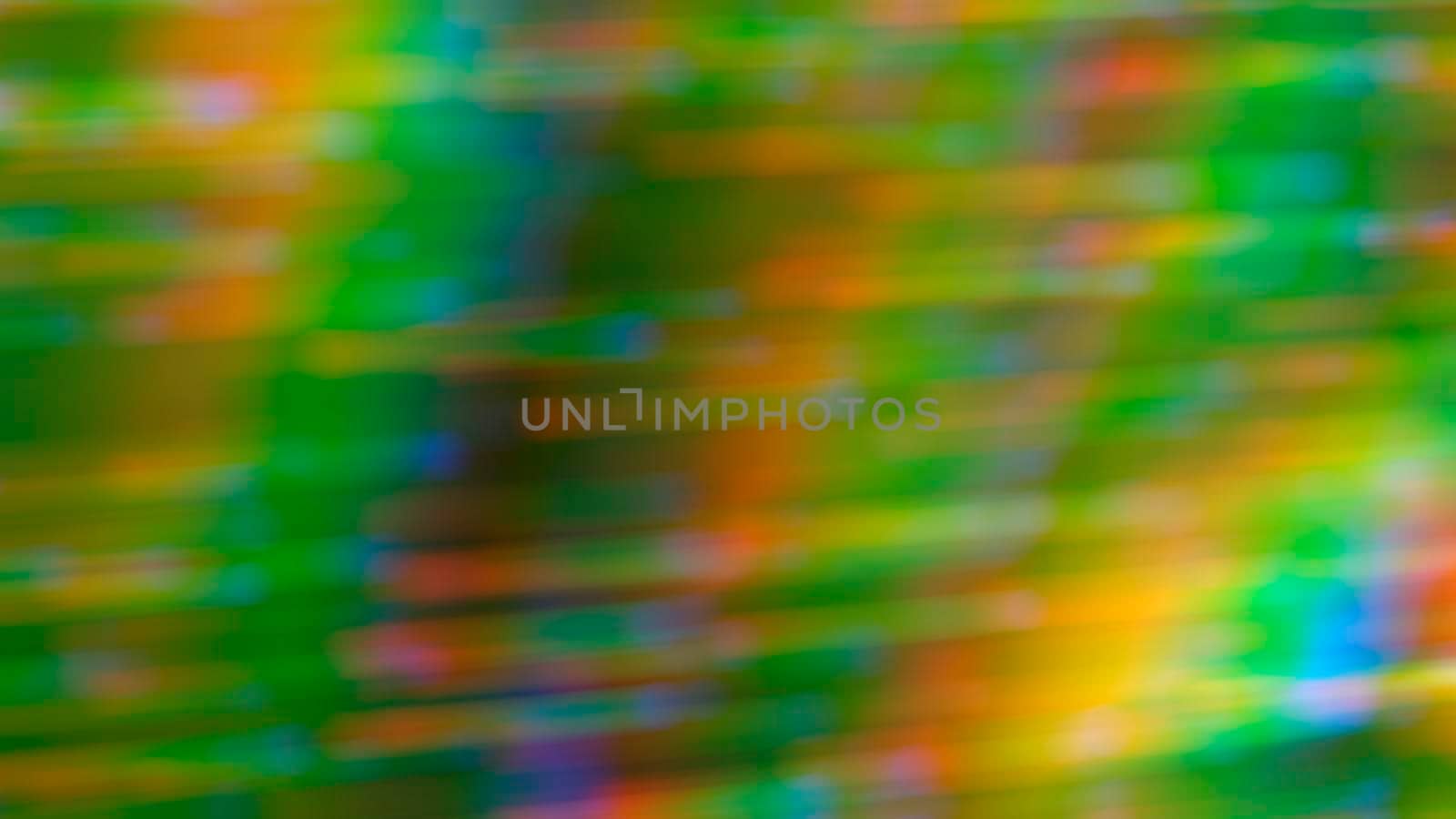 Abstract blurry green background with rainbow highlights.