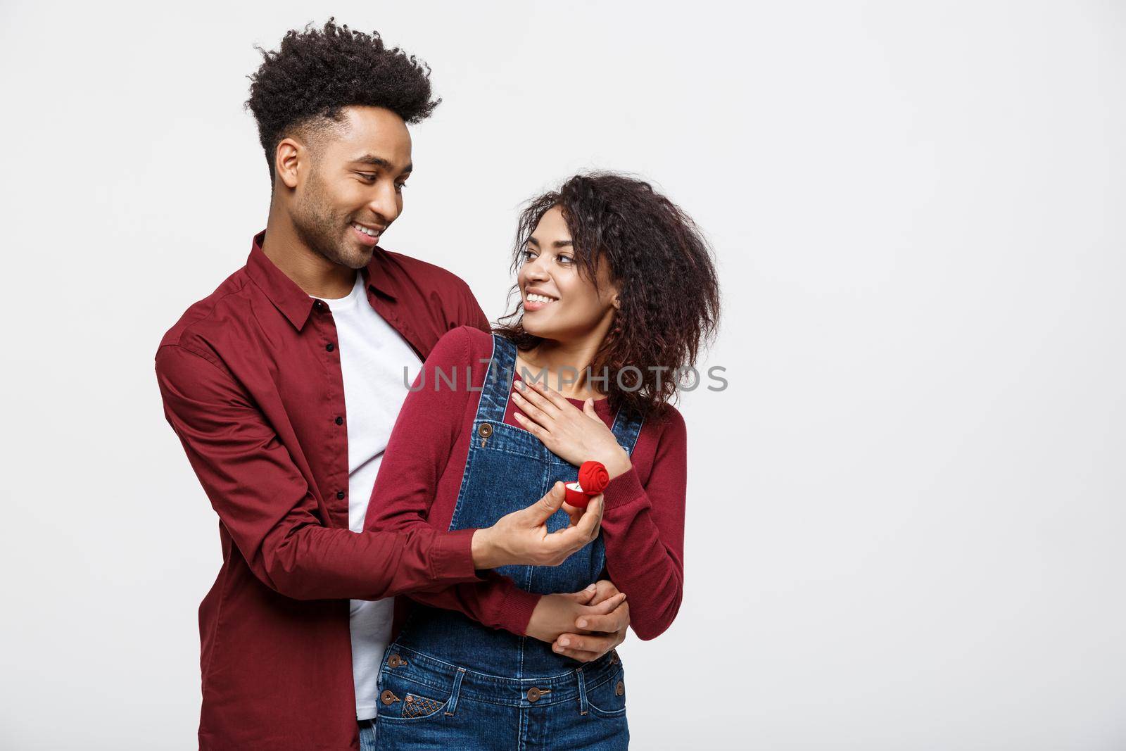 Young handsome african american man surprisingly ask her girlfriend for proposal