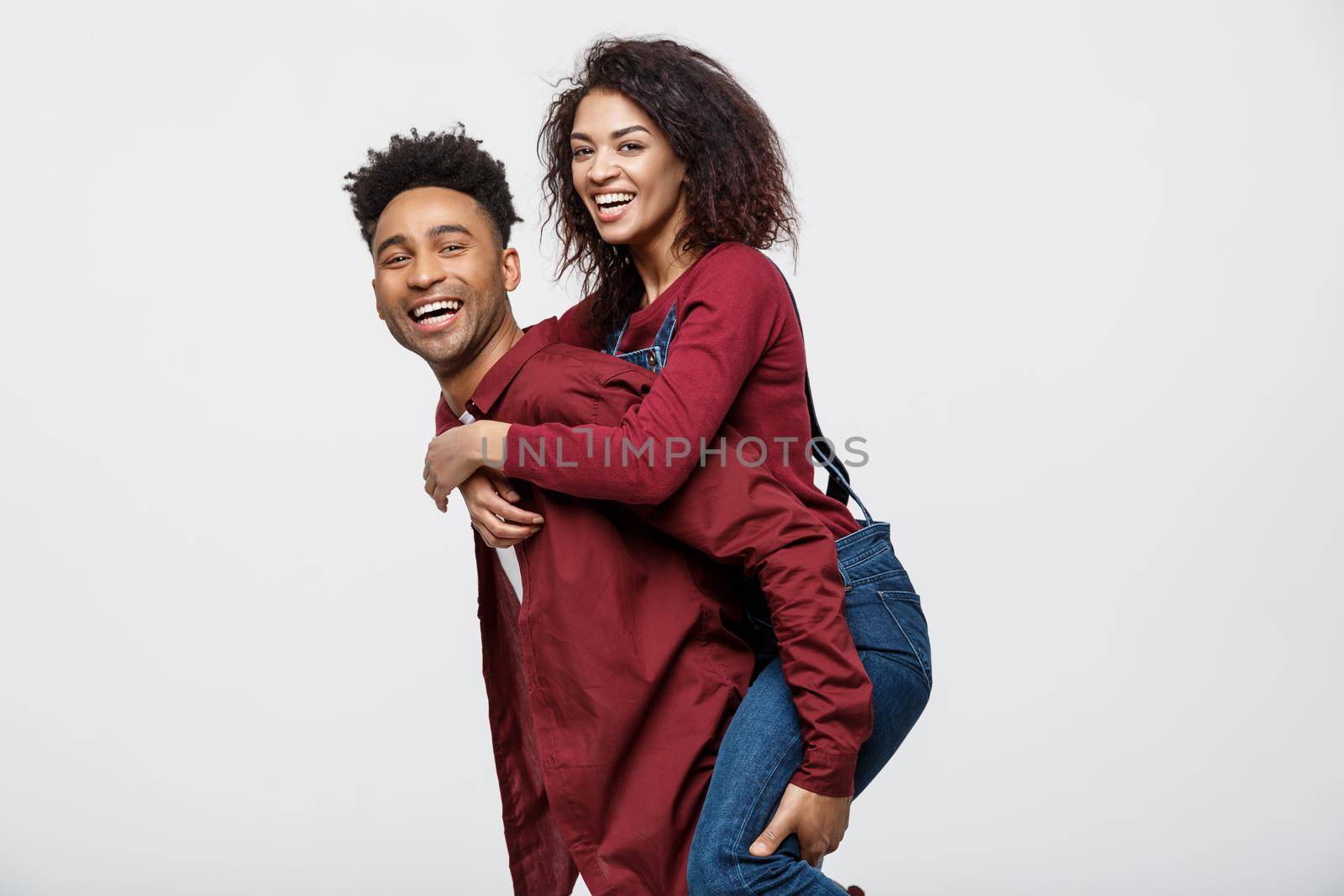 Close-up young african american couple enjoy riding back. by Benzoix