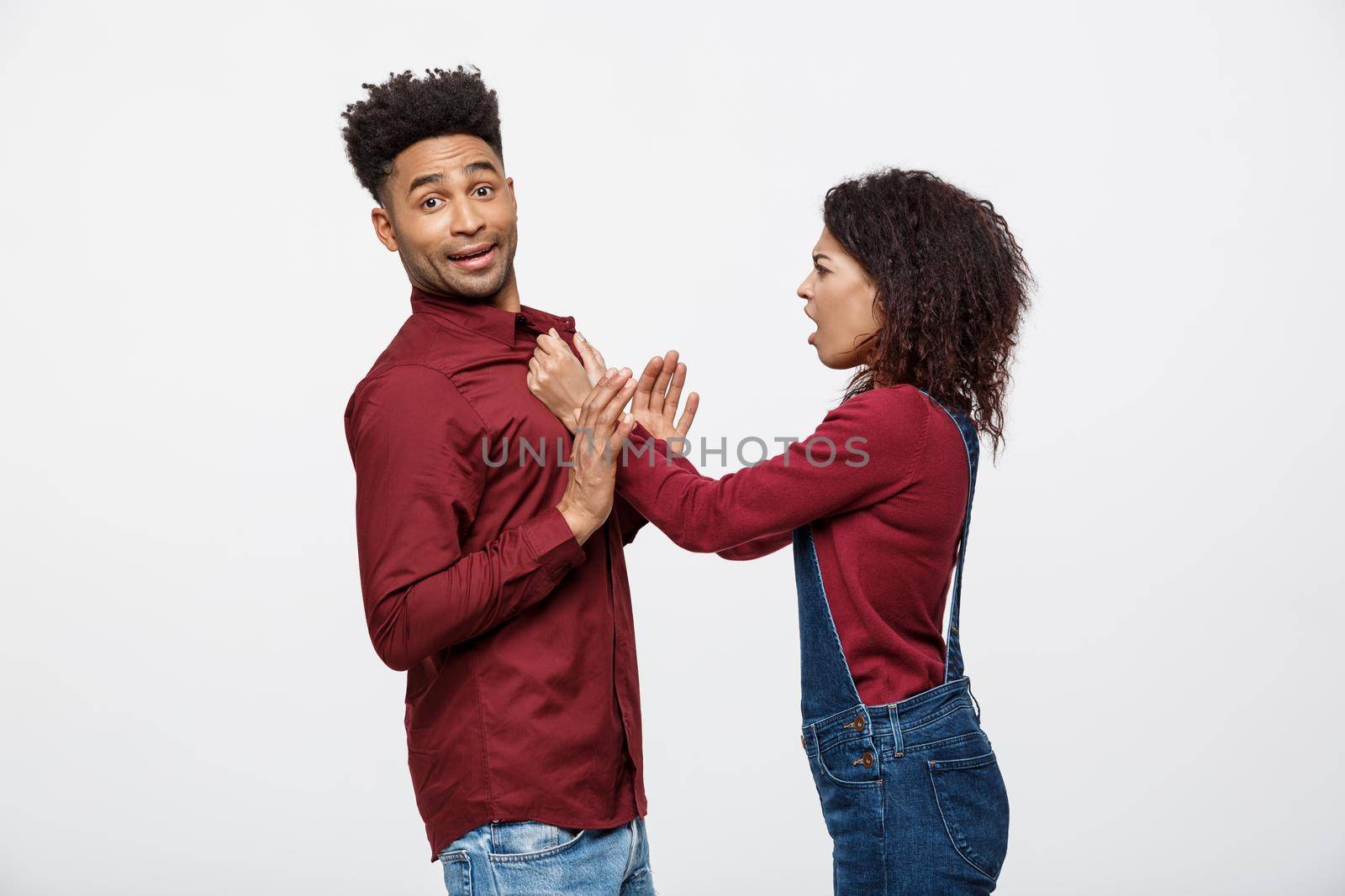 Unhappy African American couple in casual clothes arguing and figthing. by Benzoix