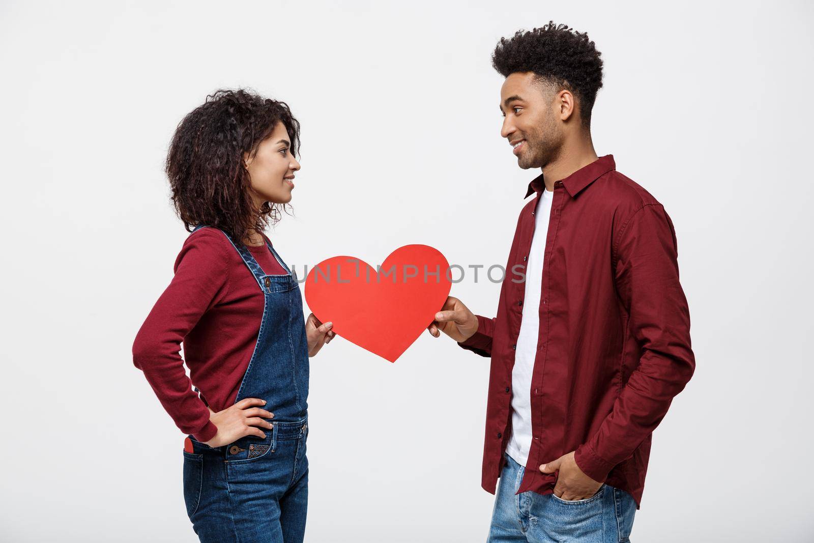 Young happy african american couple in love holding red paper heart