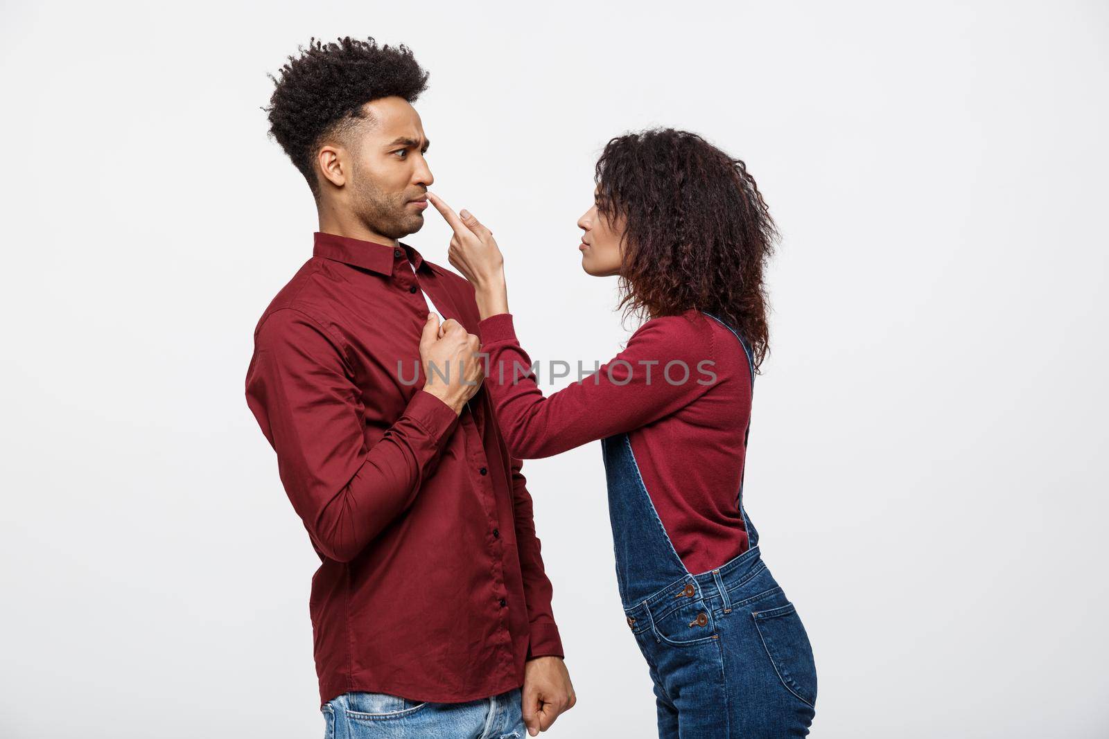 Unhappy African American couple in casual clothes arguing and figthing