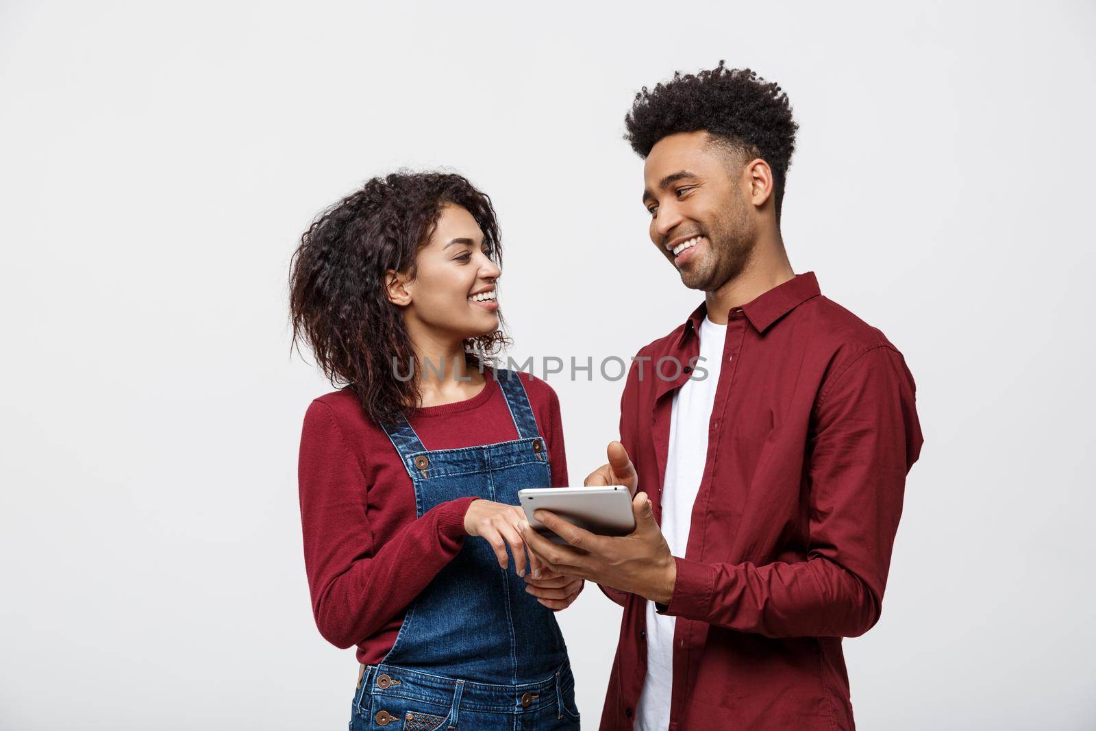 Modern african american people working on tablet with isolated on white background. by Benzoix