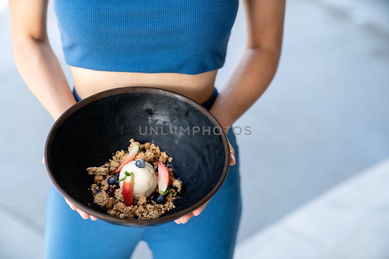 Woman served ice cream bowl with fruit and granola. by sirawit99