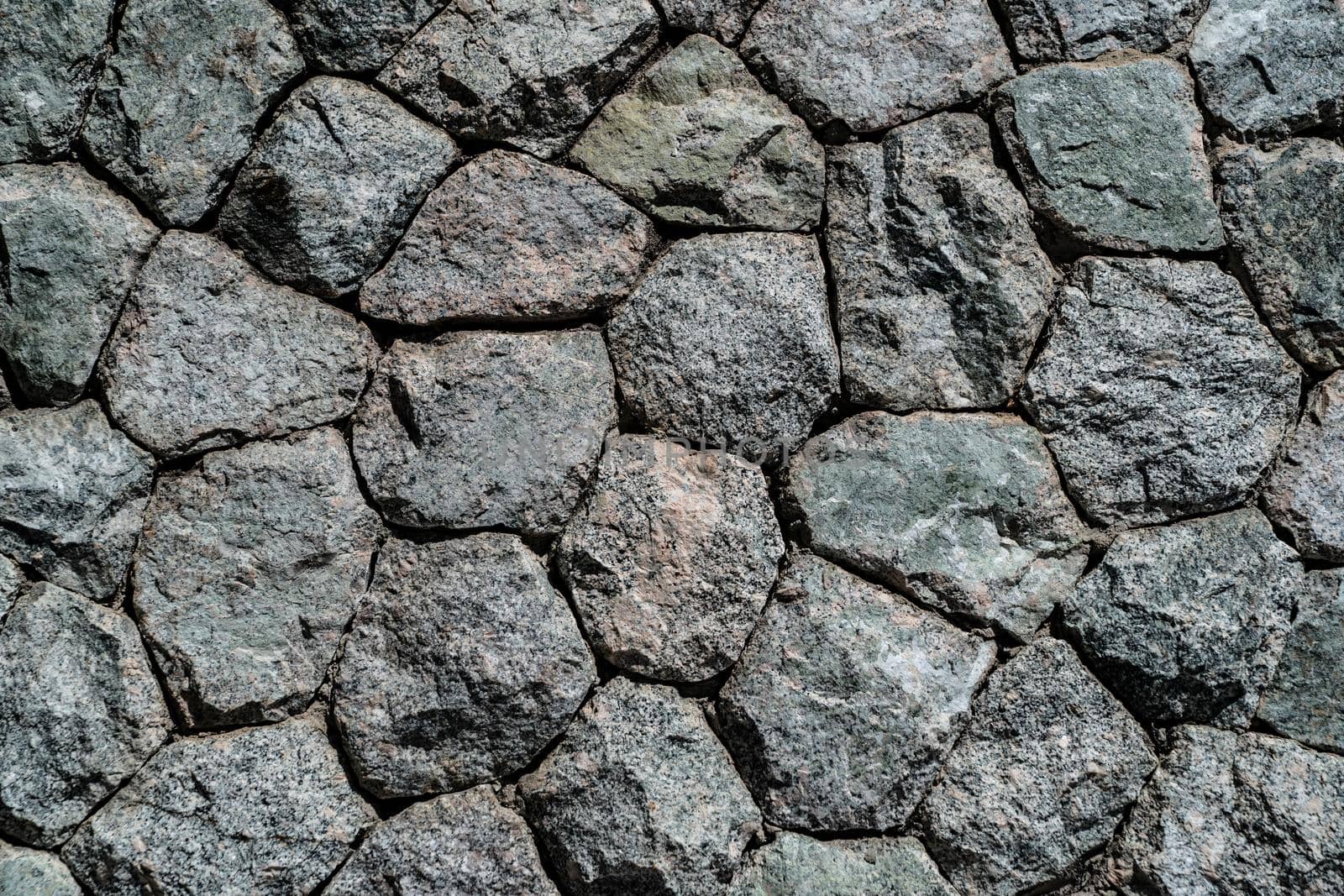 The stone wall constructed by gray rock stone.