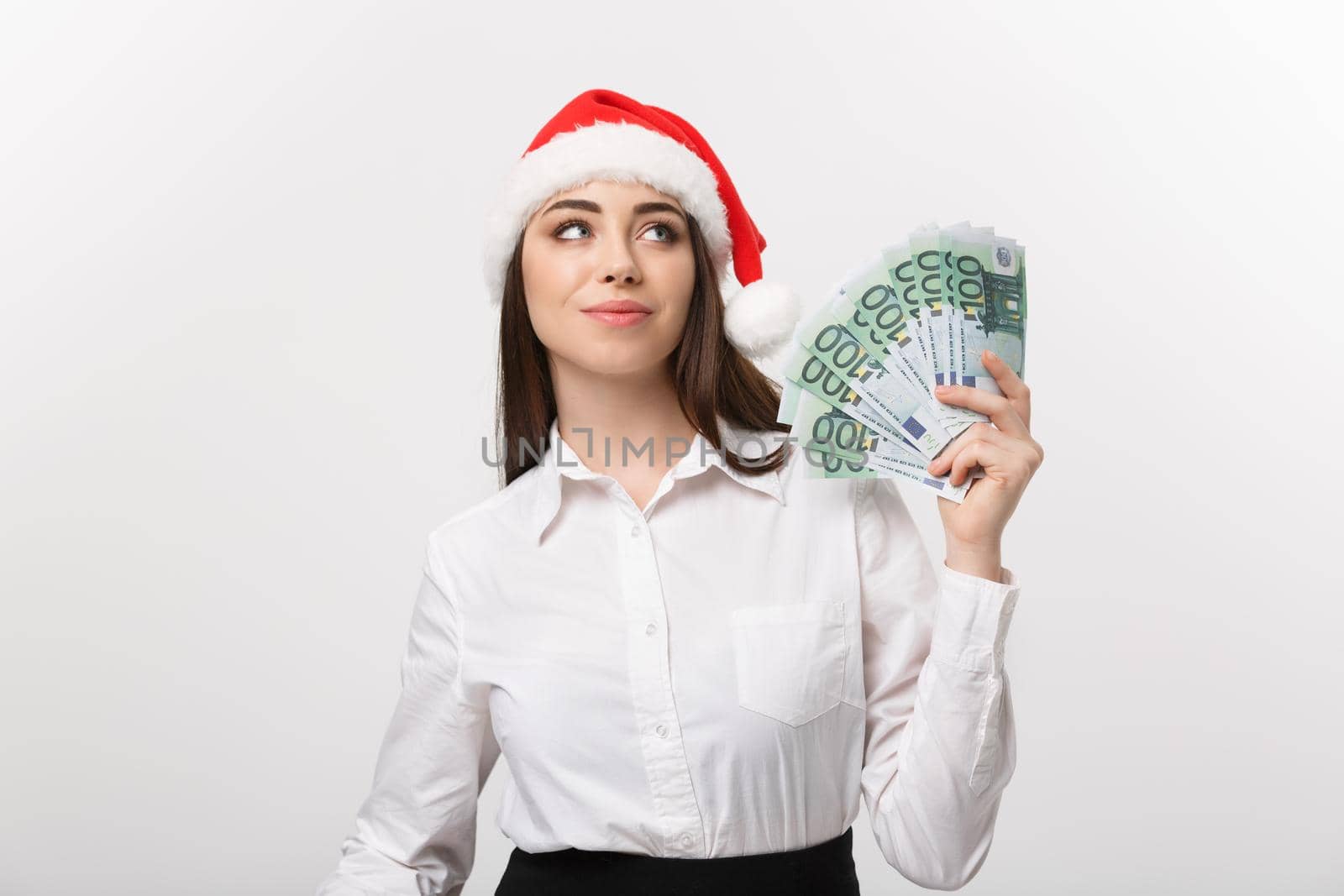 Christmas and Financial concept - Young confident business woman showing money in front of her with happy face. by Benzoix