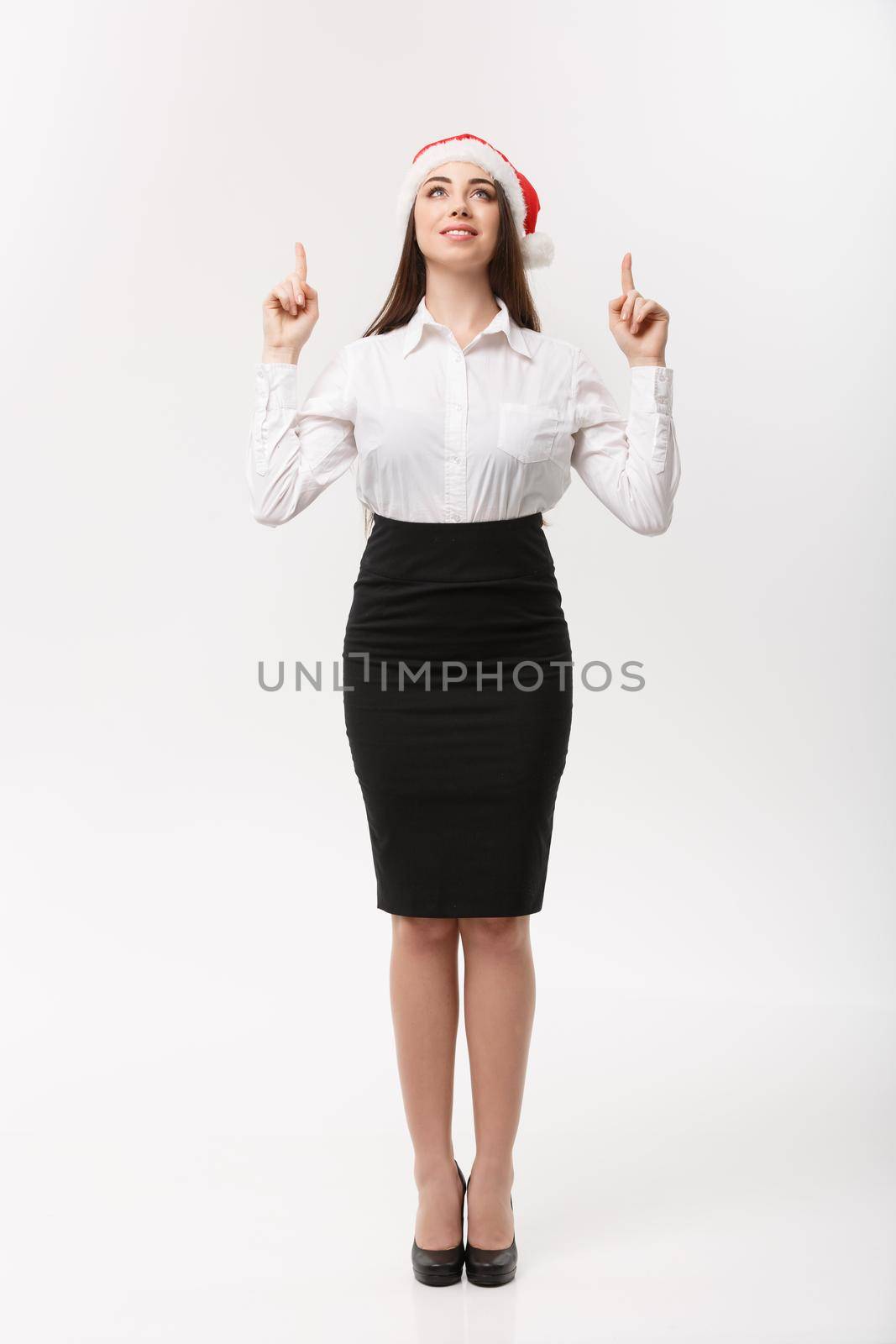 Business Concept - Modern caucasian business woman in the white studio background pointing finger upward presenting product. by Benzoix