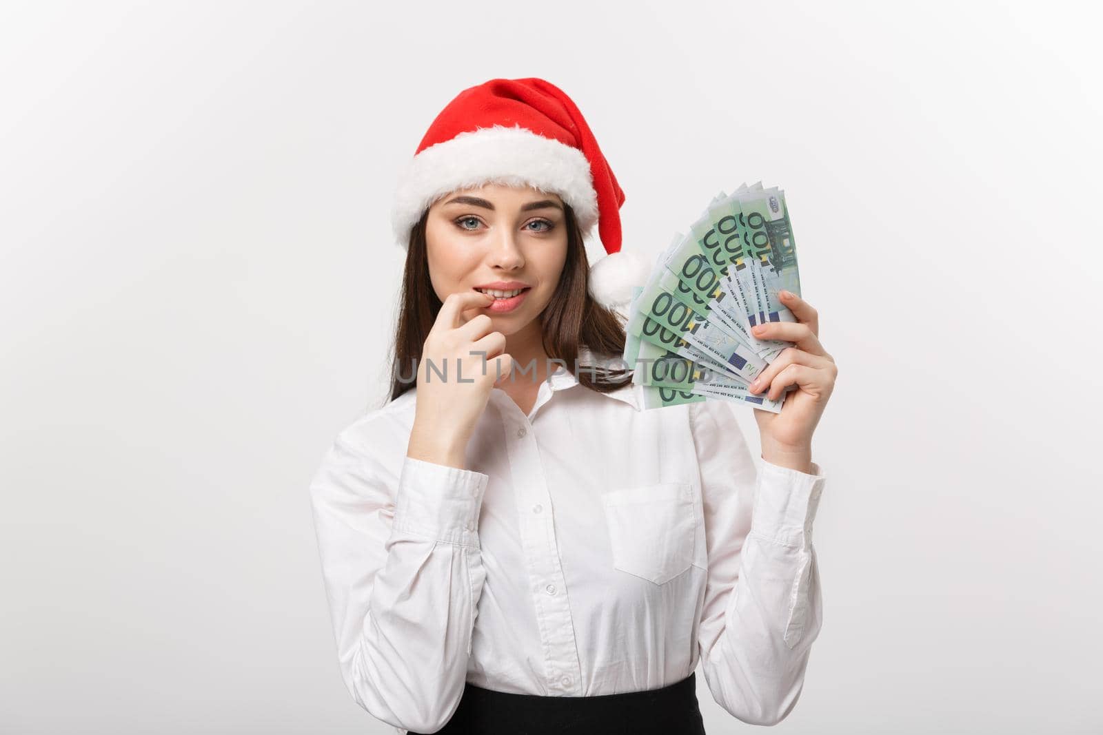 Christmas and Financial concept - Young confident business woman showing money in front of her with happy face.