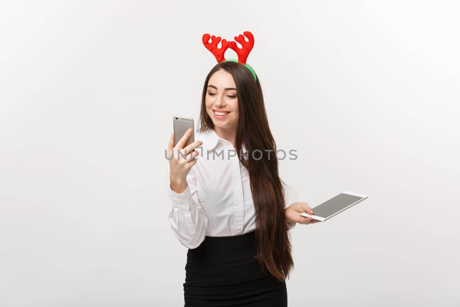 Business Concept - young caucasian business woman in Christmas theme playing moblie phone with surprising facial expression.