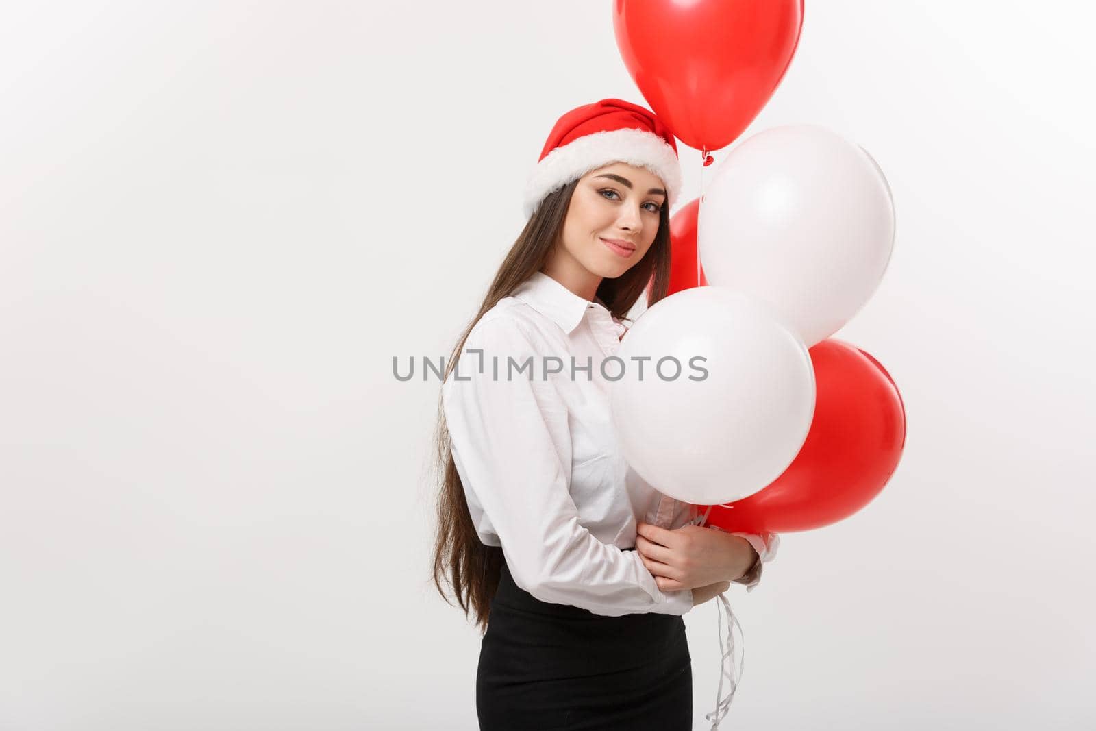 Business Concept - Beautiful young confident business woman with santa hat holding balloon celebrate for Christmas. by Benzoix