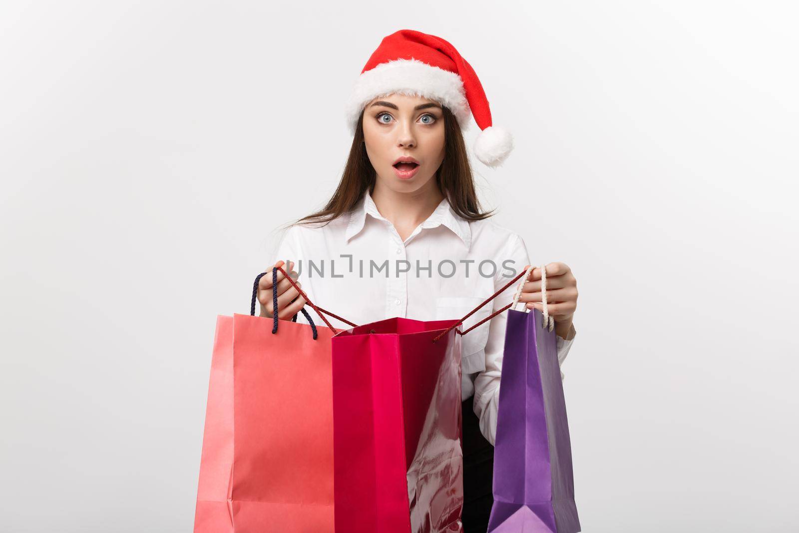 Christmas Concept - beautiful caucasian business woman shocking with gift inside shopping bag.