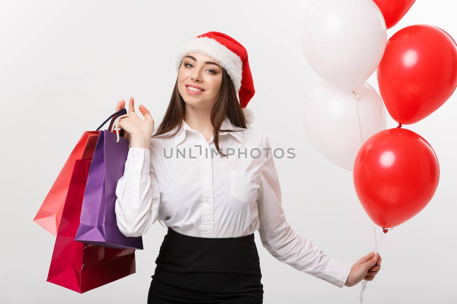 Christmas Concept - beautiful caucasian business woman happy holding shopping bags and ballons. by Benzoix