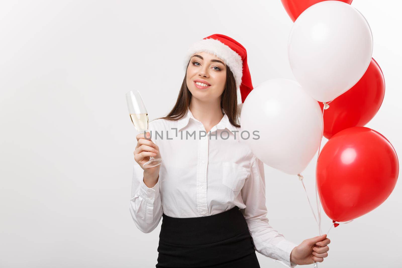 Christmas Celebration - Young beautiful business woman celebrating christmas with glass of champagne and balloon.