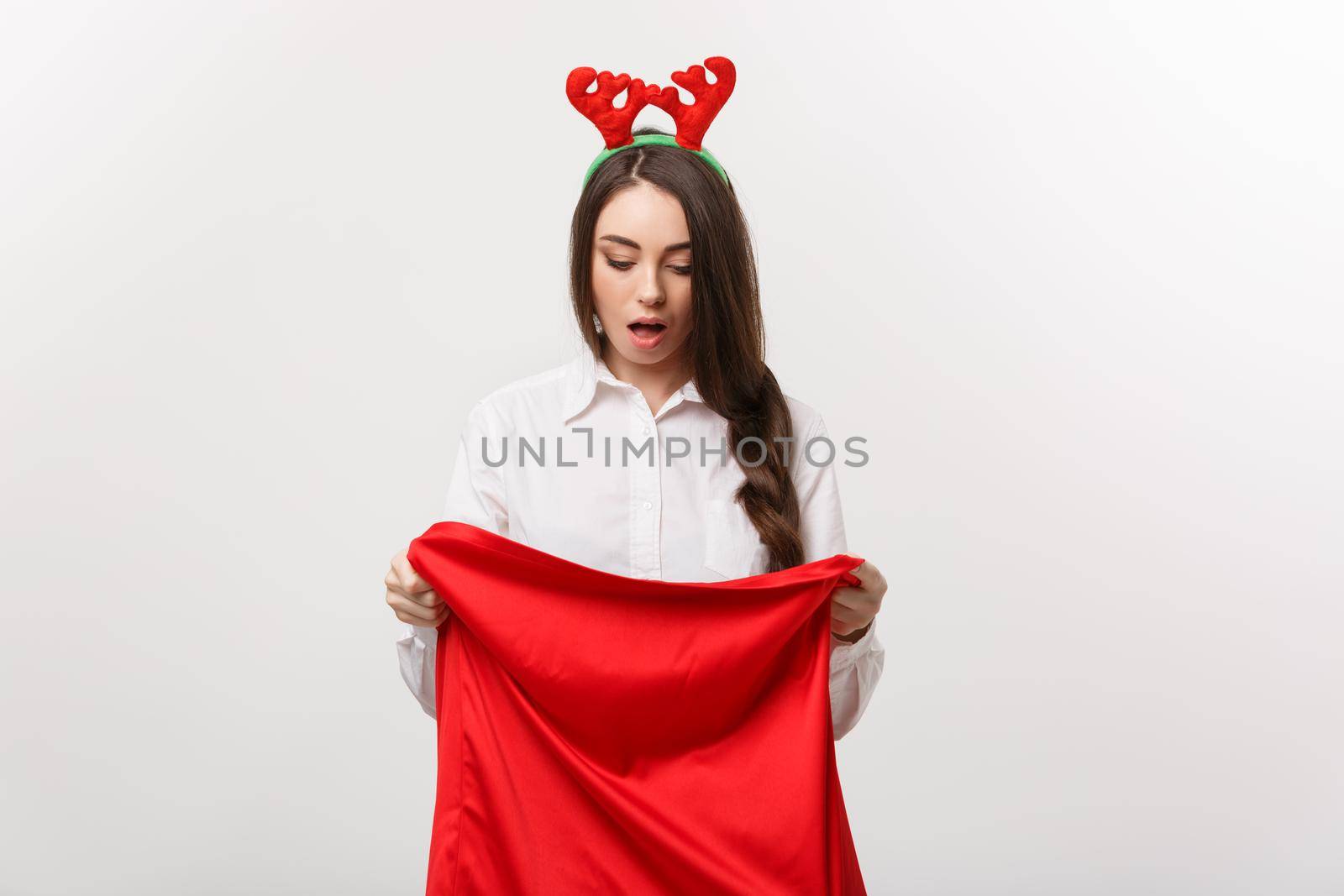 Christmas Concept - Young beautiful business woman surprise with present in santa bag. by Benzoix