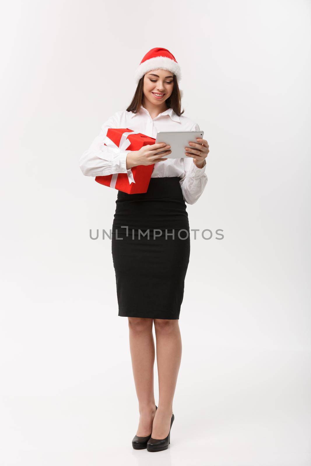 Business Concept - young business woman woking on digital tablet in Christmas day. by Benzoix