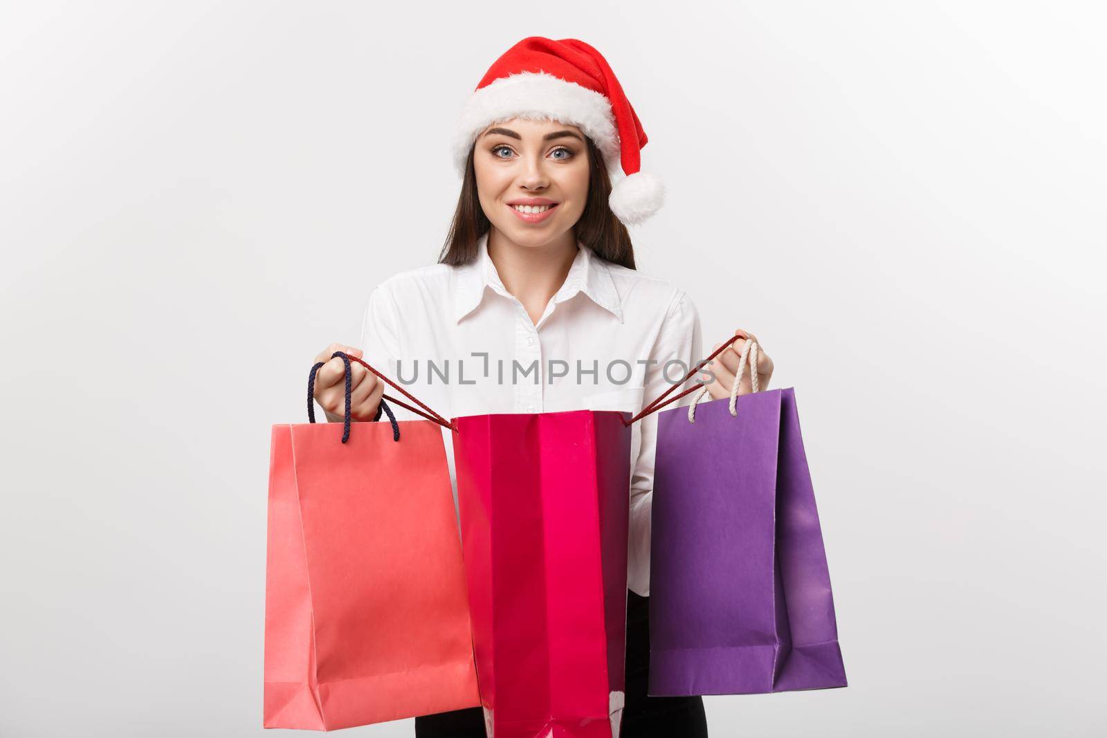 Christmas Concept - beautiful caucasian business woman shocking with gift inside shopping bag.