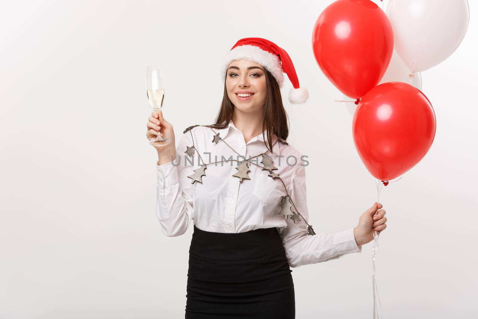 Christmas Celebration - Young beautiful business woman celebrating christmas with glass of champagne and balloon.