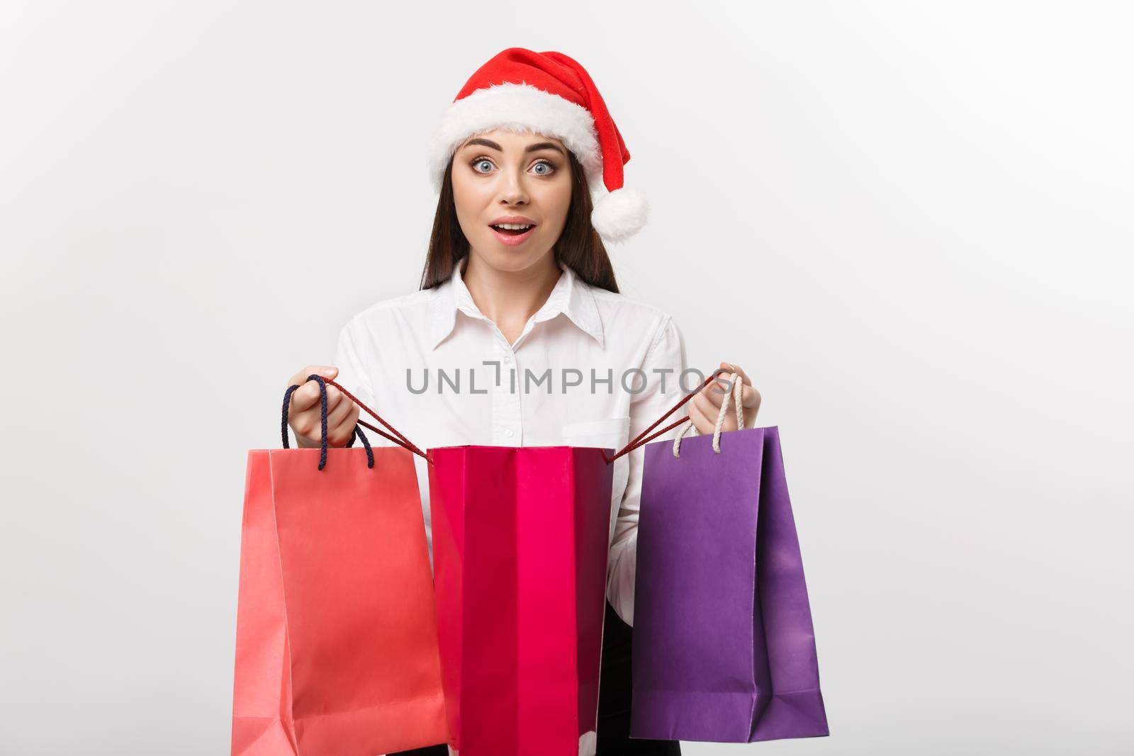 Christmas Concept - beautiful caucasian business woman shocking with gift inside shopping bag. by Benzoix