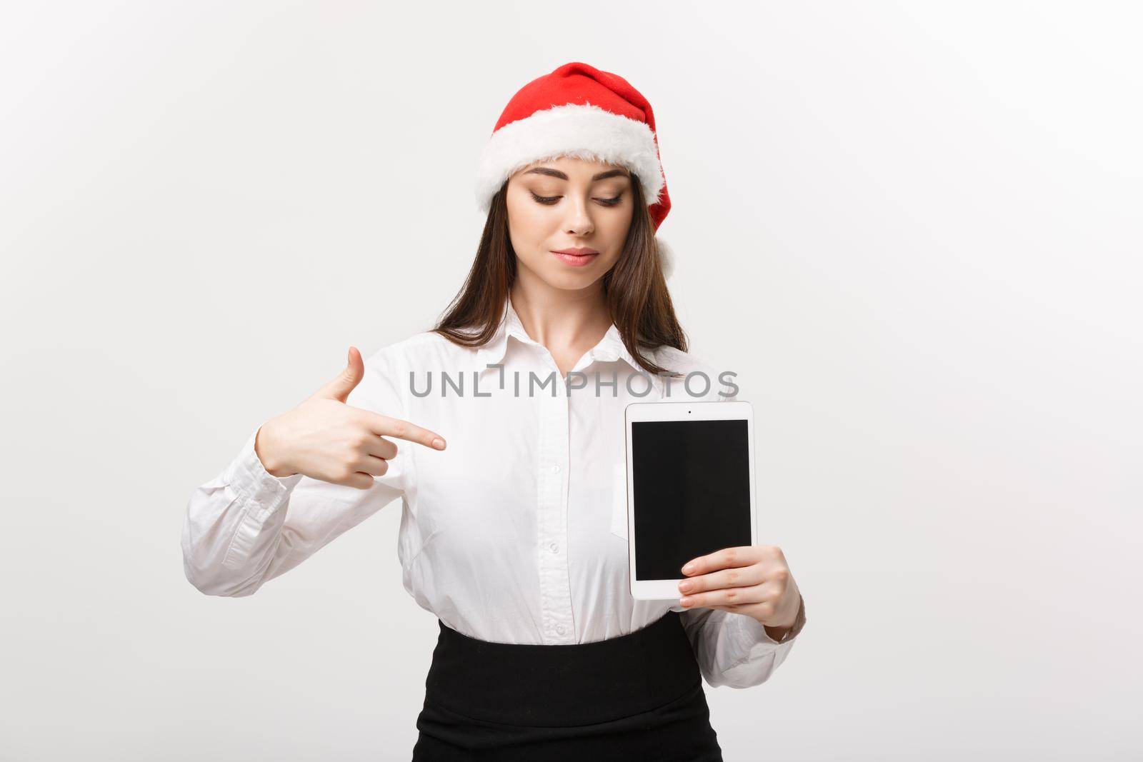 Business Concept - young caucasian business woman in Christmas theme showing and pointing to digital tablet. by Benzoix