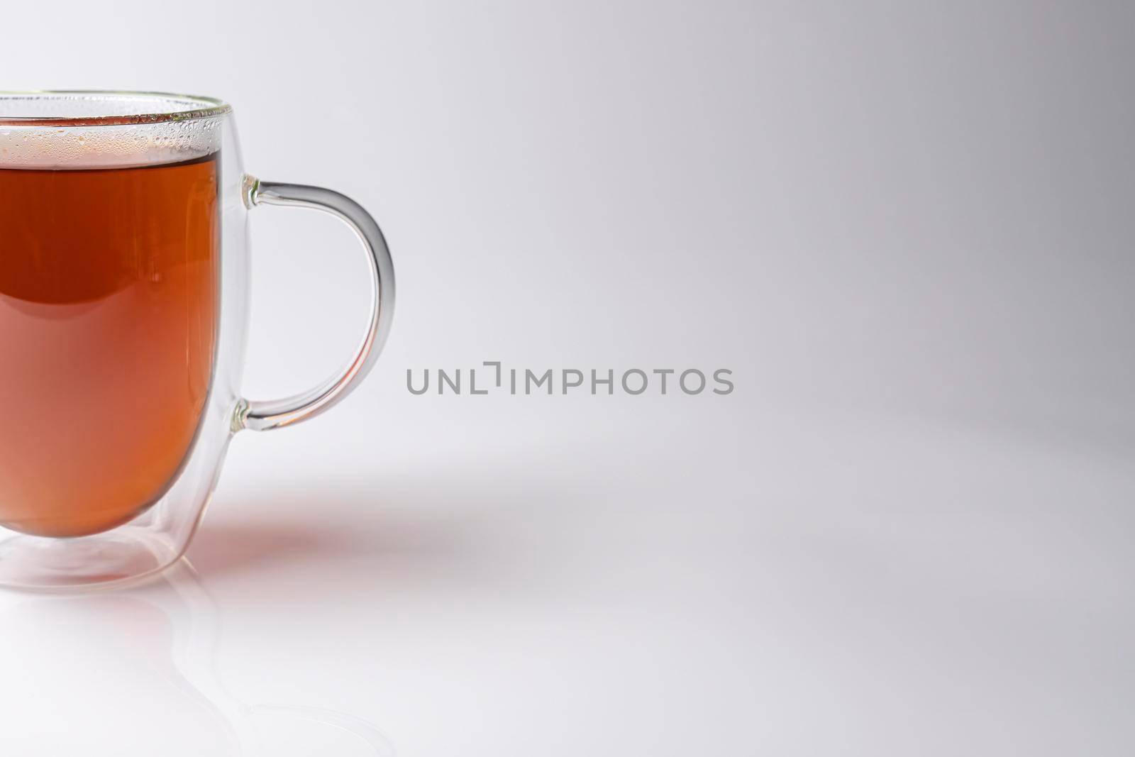glass thermo mug with black tea on a white background. High quality photo