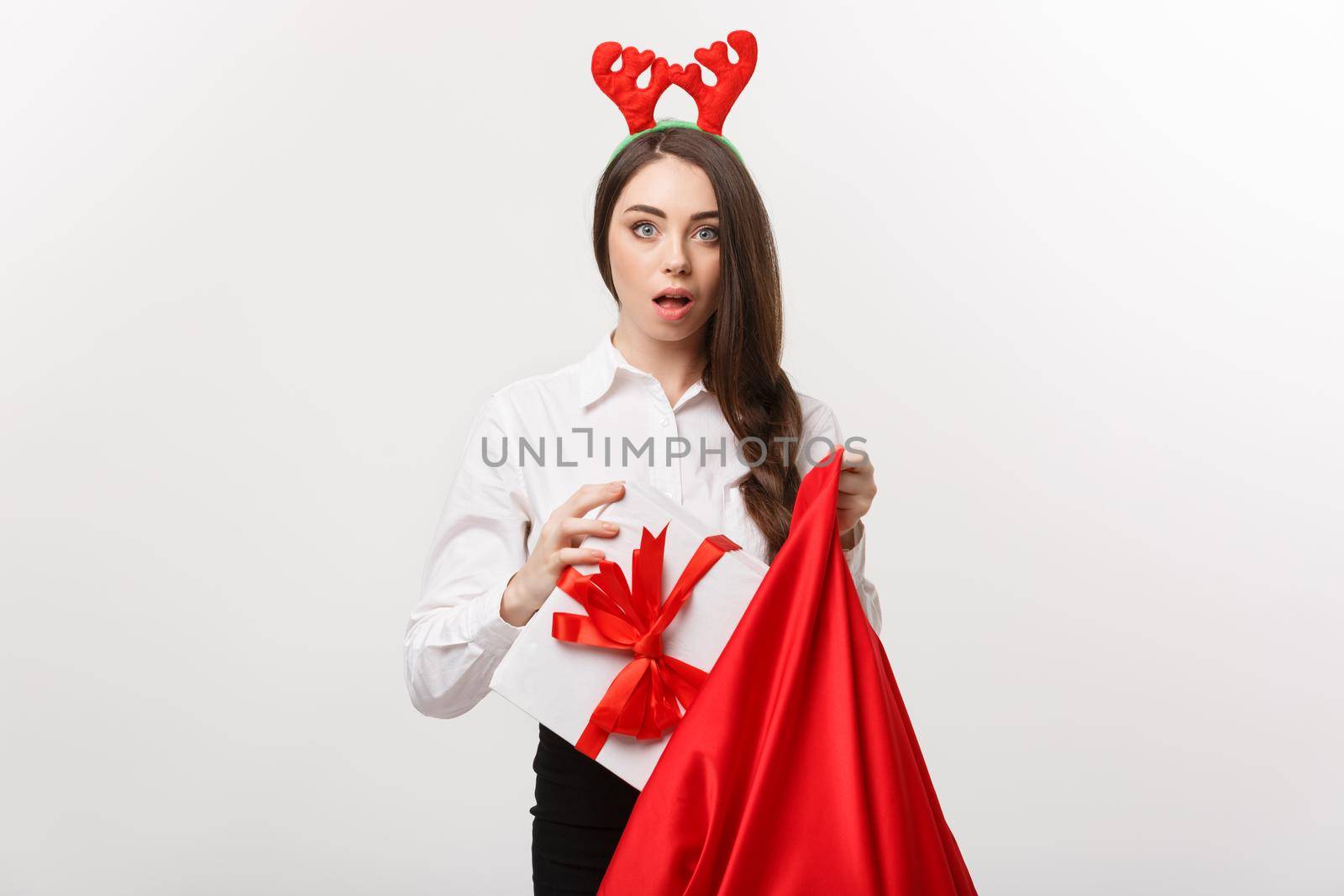 Christmas Concept - Young beautiful business woman happy with present in santa bag. by Benzoix