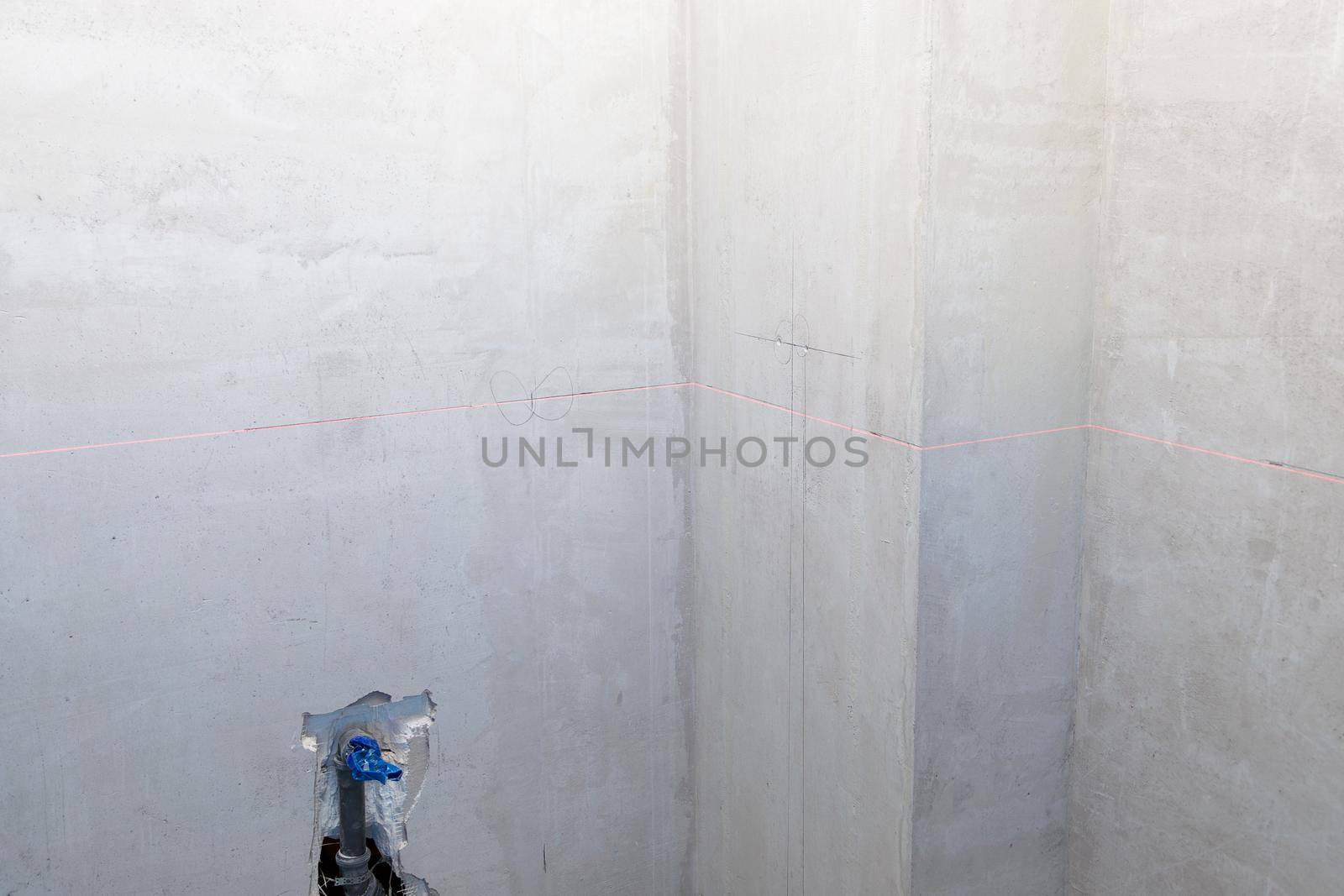 Laser marking of the level on the wall, construction, interior finishing works. Construction laser level for marking electrical outlets.
