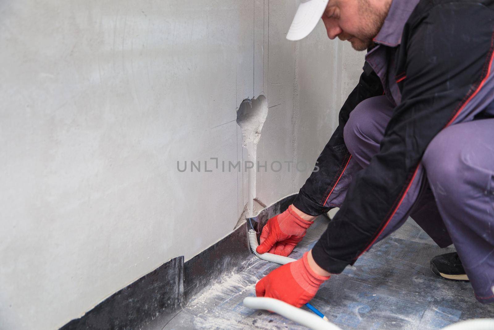 Electrician with a reel of corrugated cable for outlets. Close-up