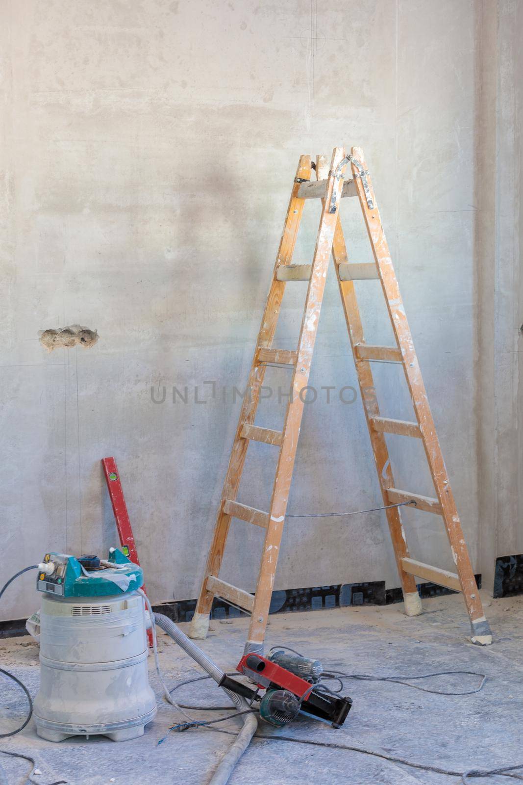 A room with a stepladder and a tool for repairs in the process of finishing the apartment.
