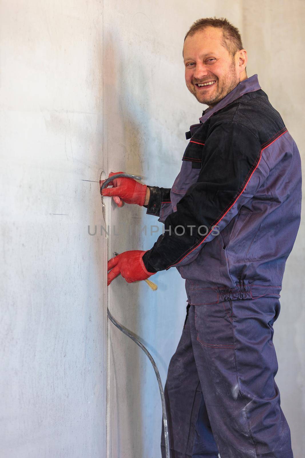 An electrician is laying a cable in an electrical ditch. Apartment renovation. Close-up