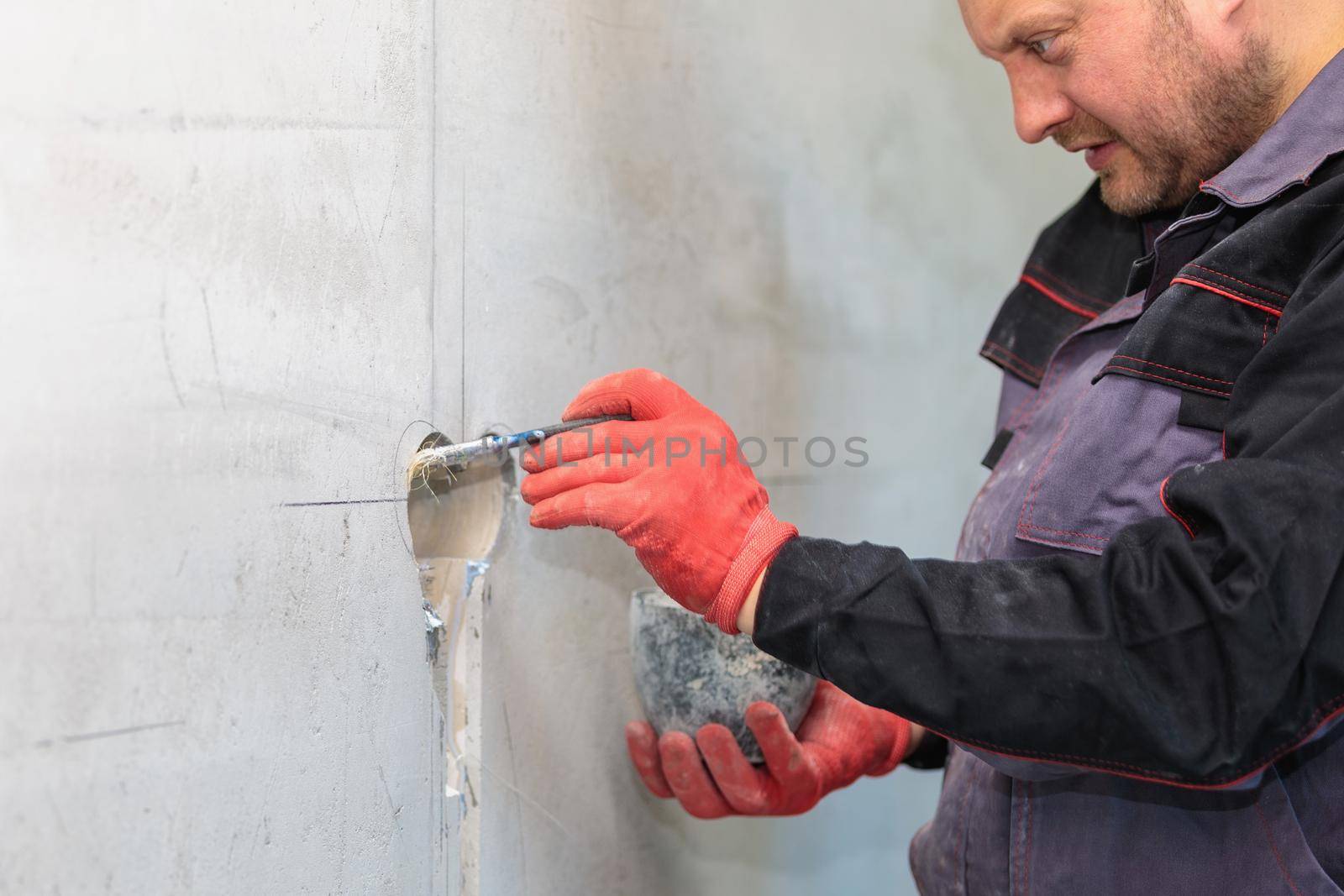 The electrician will prime the holes and channels for outlets and wires. Repair of apartments. Close-up