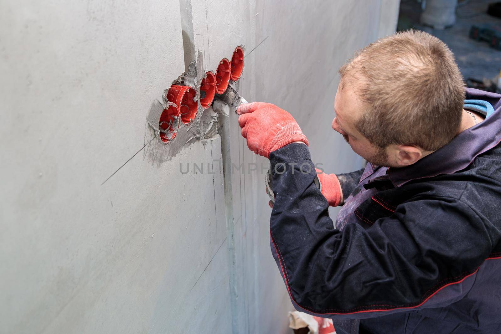 The electrician will plaster holes and channels for sockets and wires. Repair of apartments. Close-up