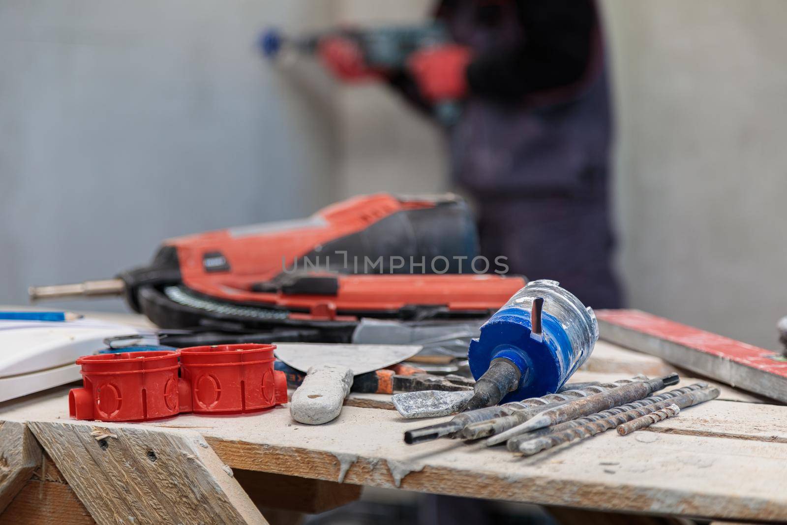 An electrician drills holes for sockets with a diamond core bit by Yurich32